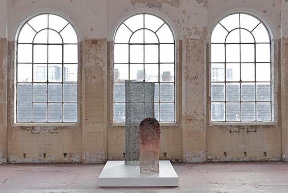 A sculpture sits in front of 3 large arched windows in the Bloomberg new contemporaries 2015 exhibition