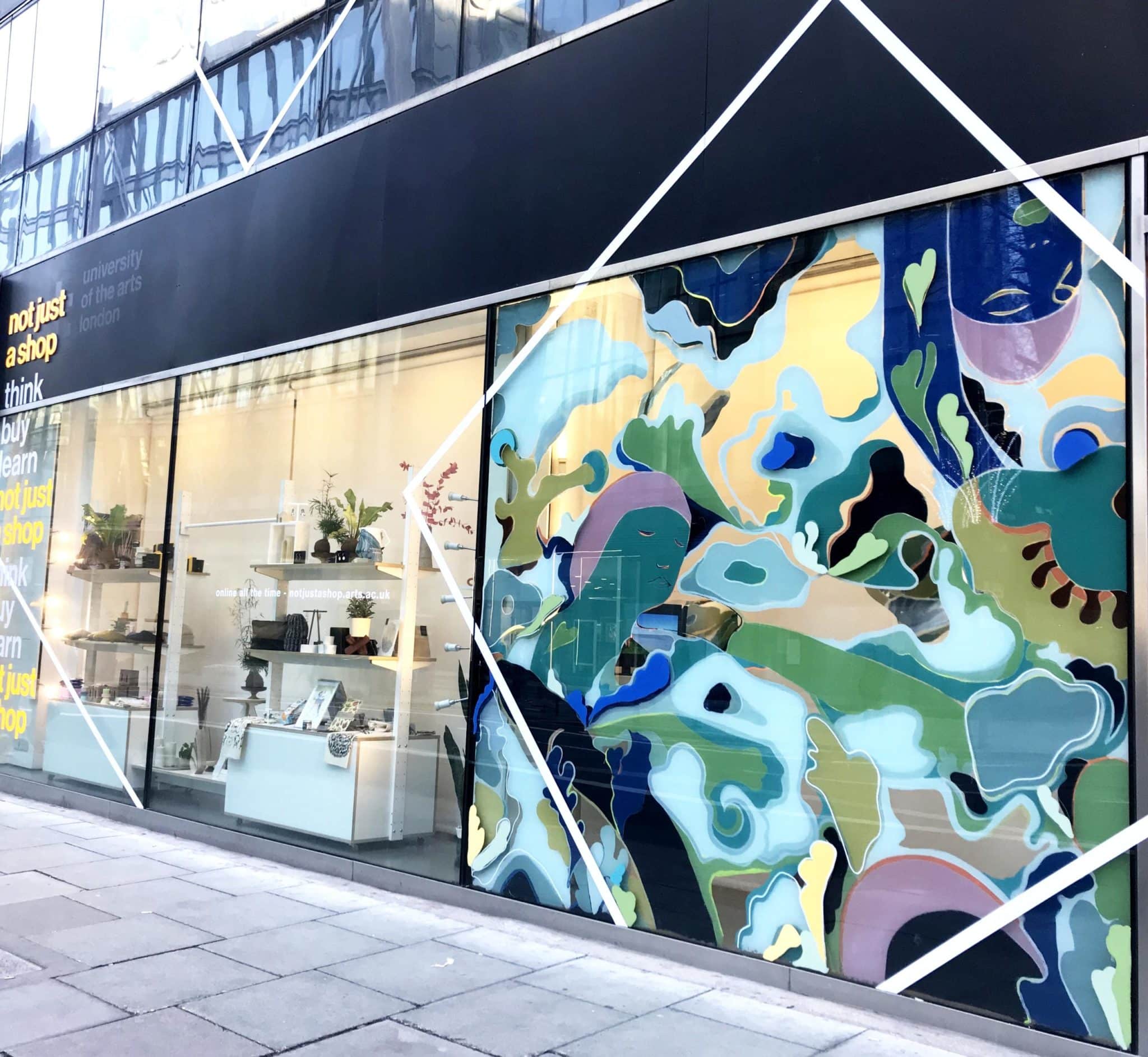 Wide shot picture of Resolutions window commission in not just a shop window. next to window display of not just a shop products for sale.