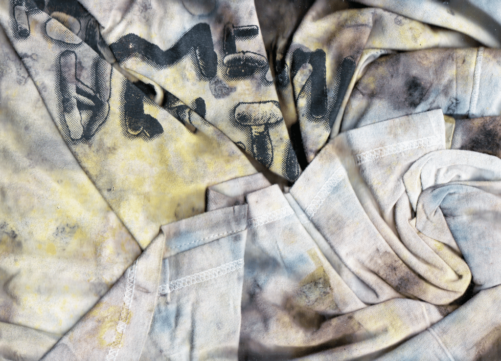 Photograph of cloth material with yellows, blues and reds dyed into it.