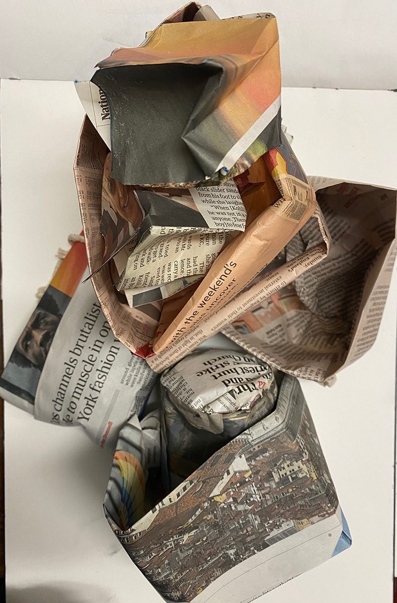photo of small forms made in newspaper - jumbled like a tower