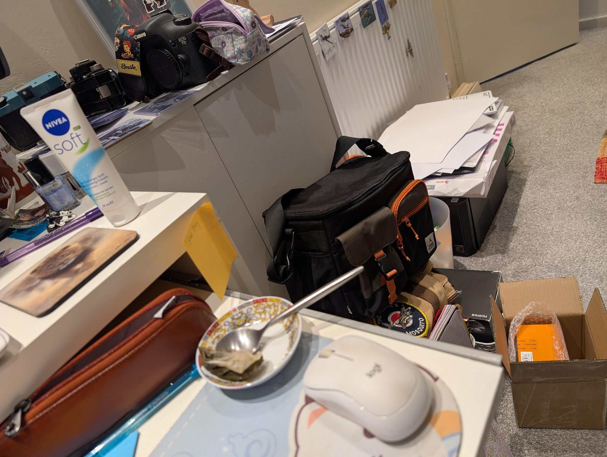 Messy home office desk and floor cover in notebooks, pens, books etc