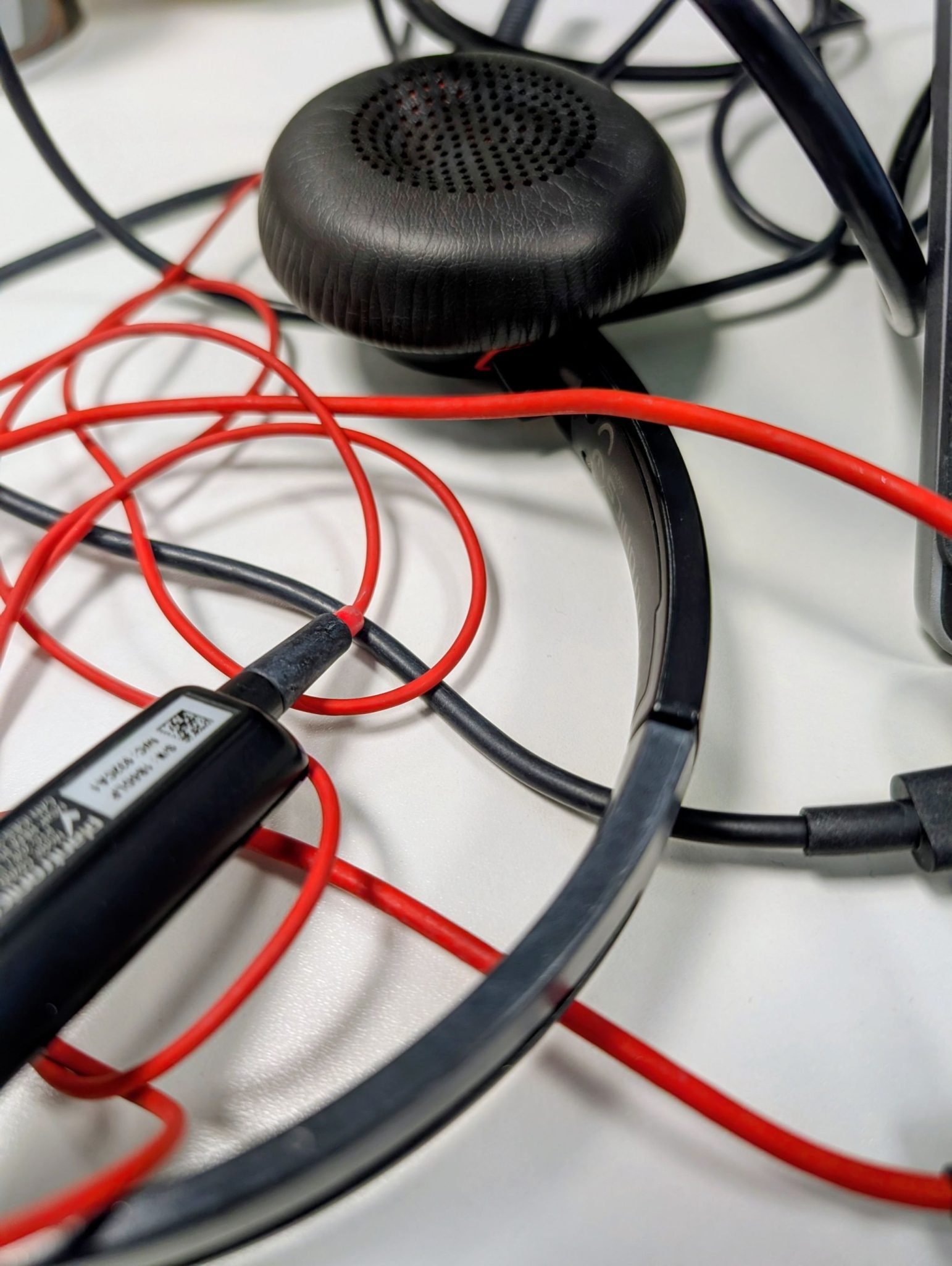 Headphones in a desk, black and white with bright red cord
