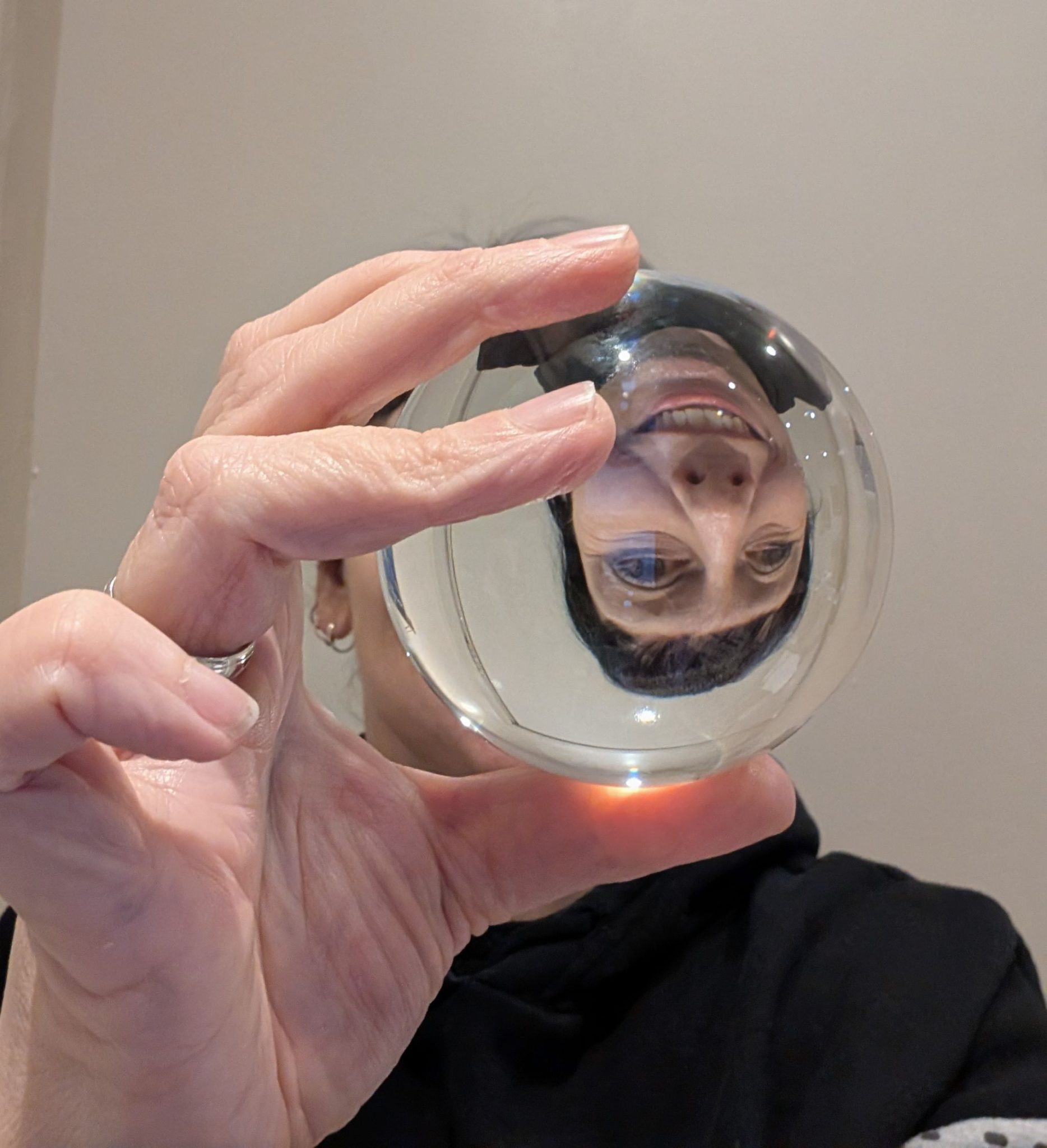 Self portrait holding a crystal lens ball showing my disembodied head as reflection in the crystal