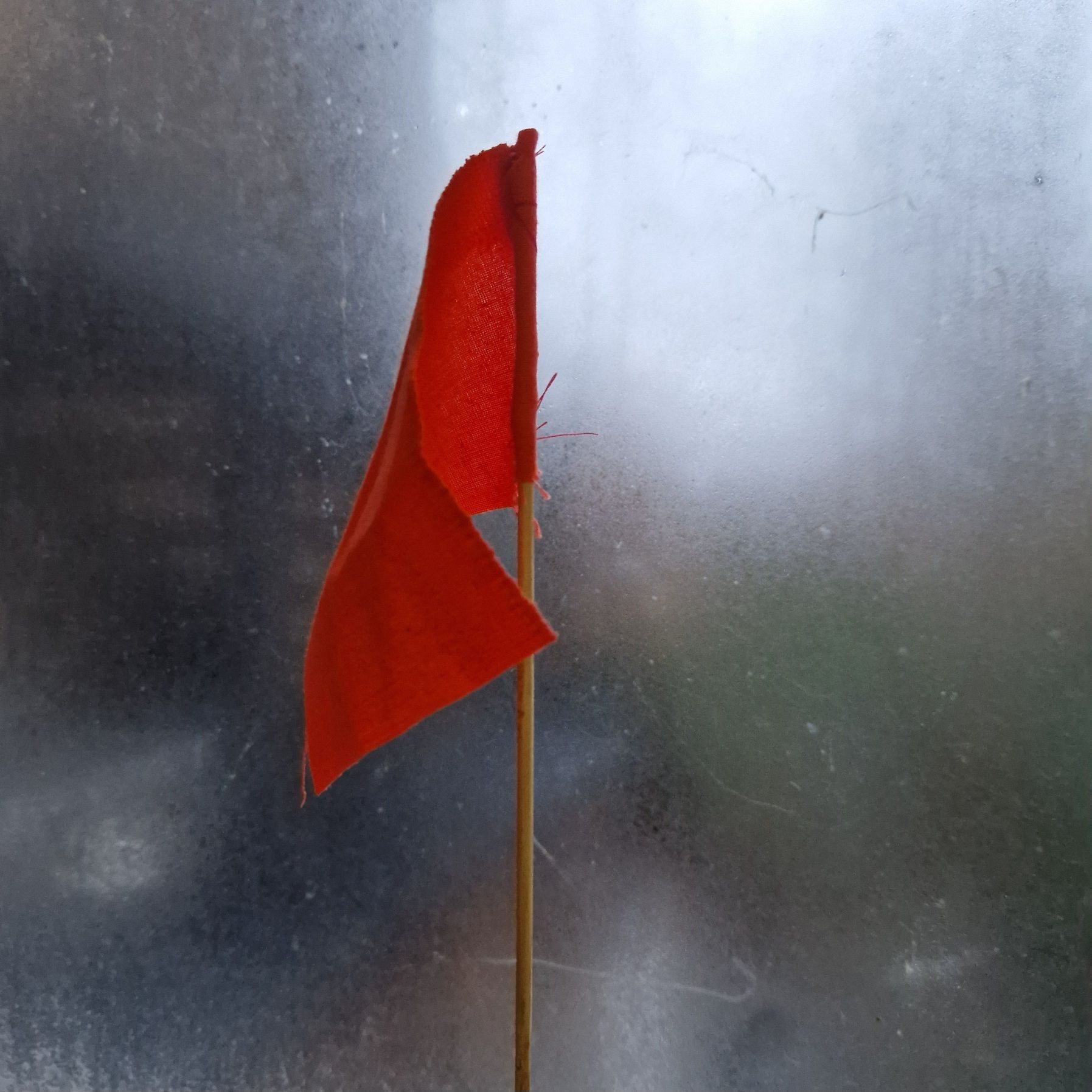 Small red flag in front of a steamed up window