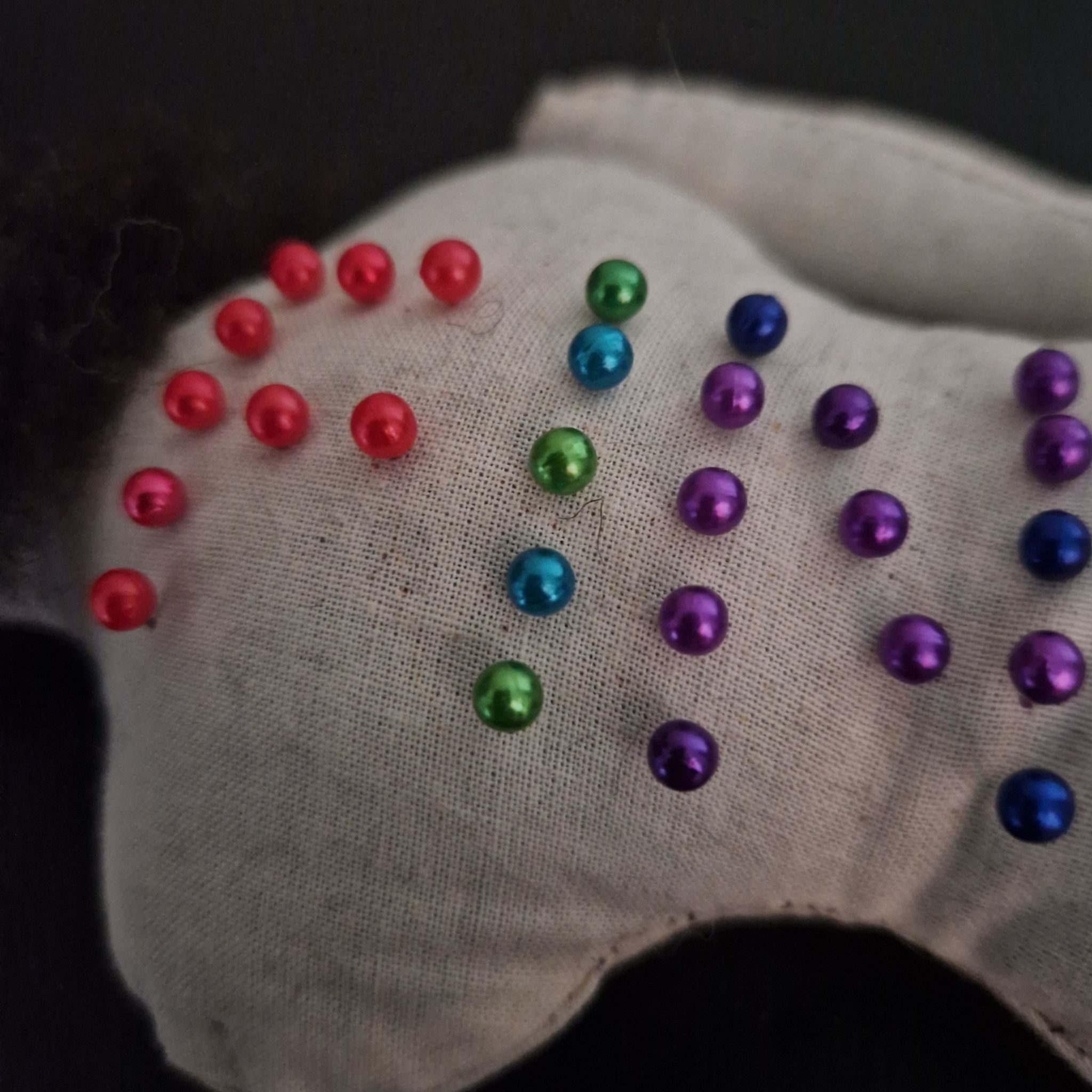 Close up of back of cloth doll laying belly down. Coloured pins spell out the word FIN, to commemorate this final entry to 30/30 2026