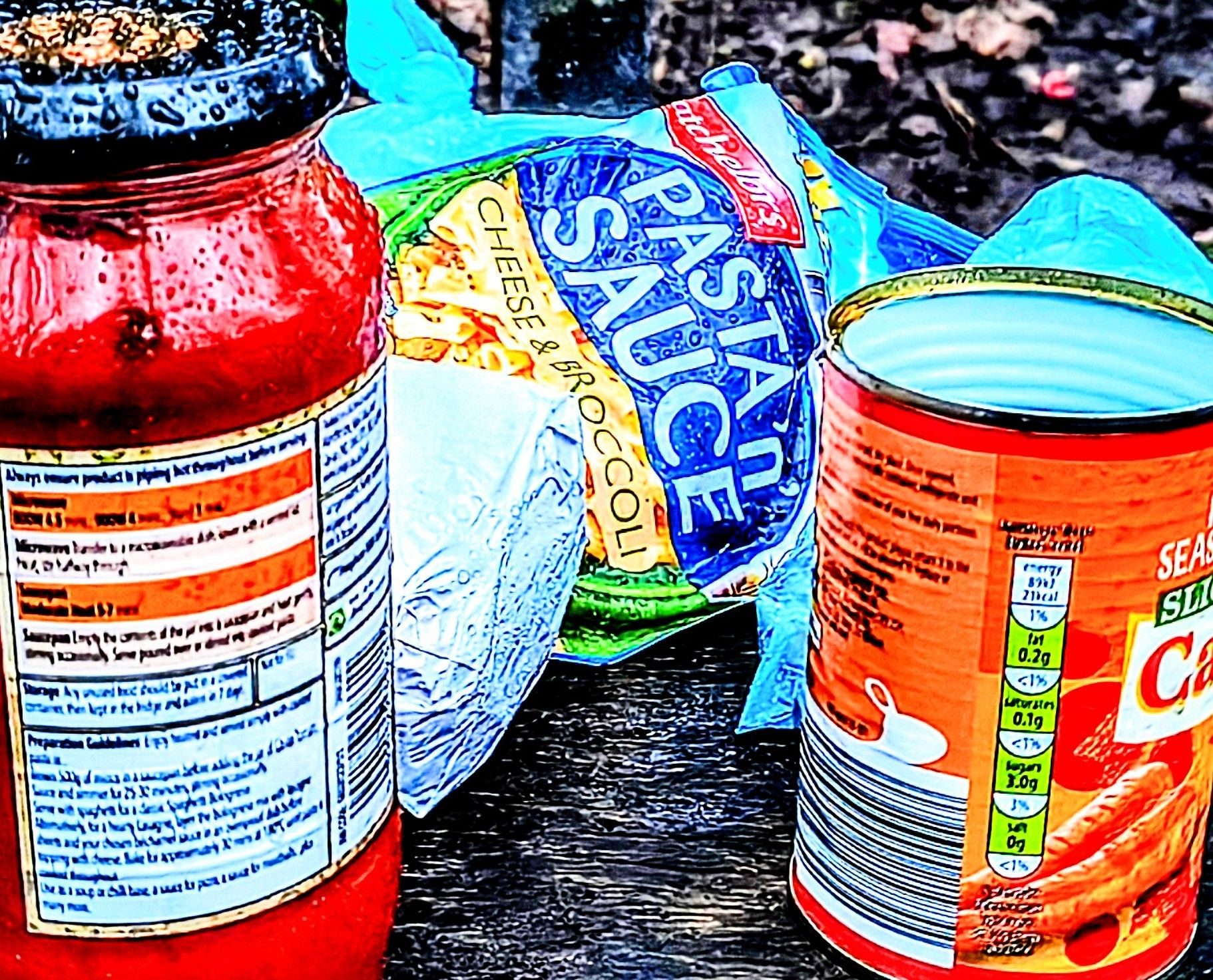 Cropped and over saturated image of a tin of carrots pasta sauce and a packet of pasta n sauce in bright colours