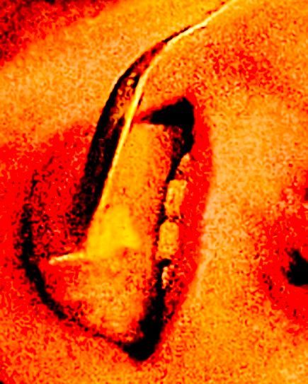 Image of a cropped and zoomed in over saturated mouth that is rotated to the left with a spoon in the mouth