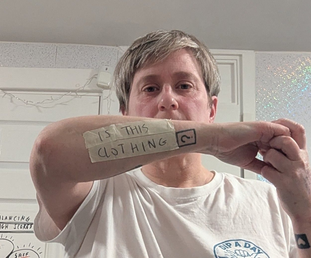 On bits of masking tape is written 'is this clothing' and the question mark is my tattoo (of a question mark)