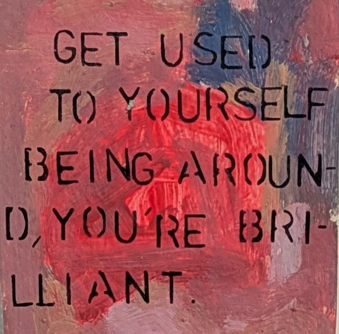 Some stenciled wording on an acrylic paint background reads: get used to yourself, you are brilliant