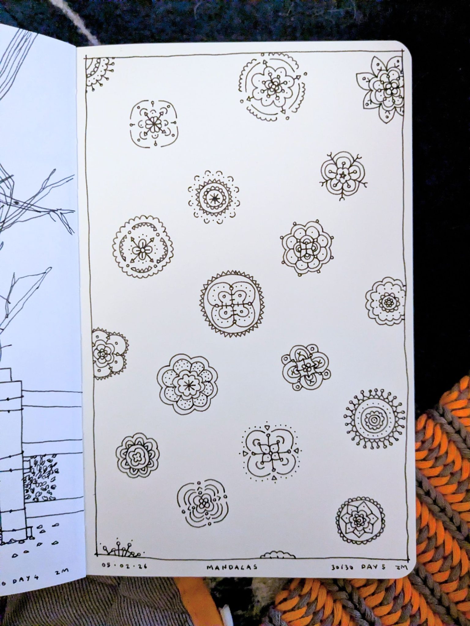 Photograph of a sketchbook page with a black and white drawing of a pattern of mini mandalas