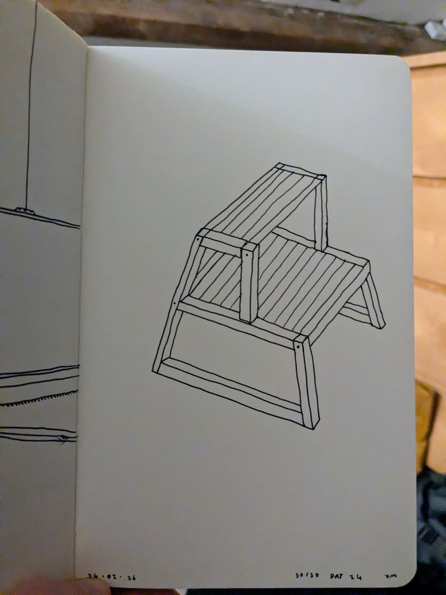 Photo of a sketchbook page showing a pen drawing of a stool