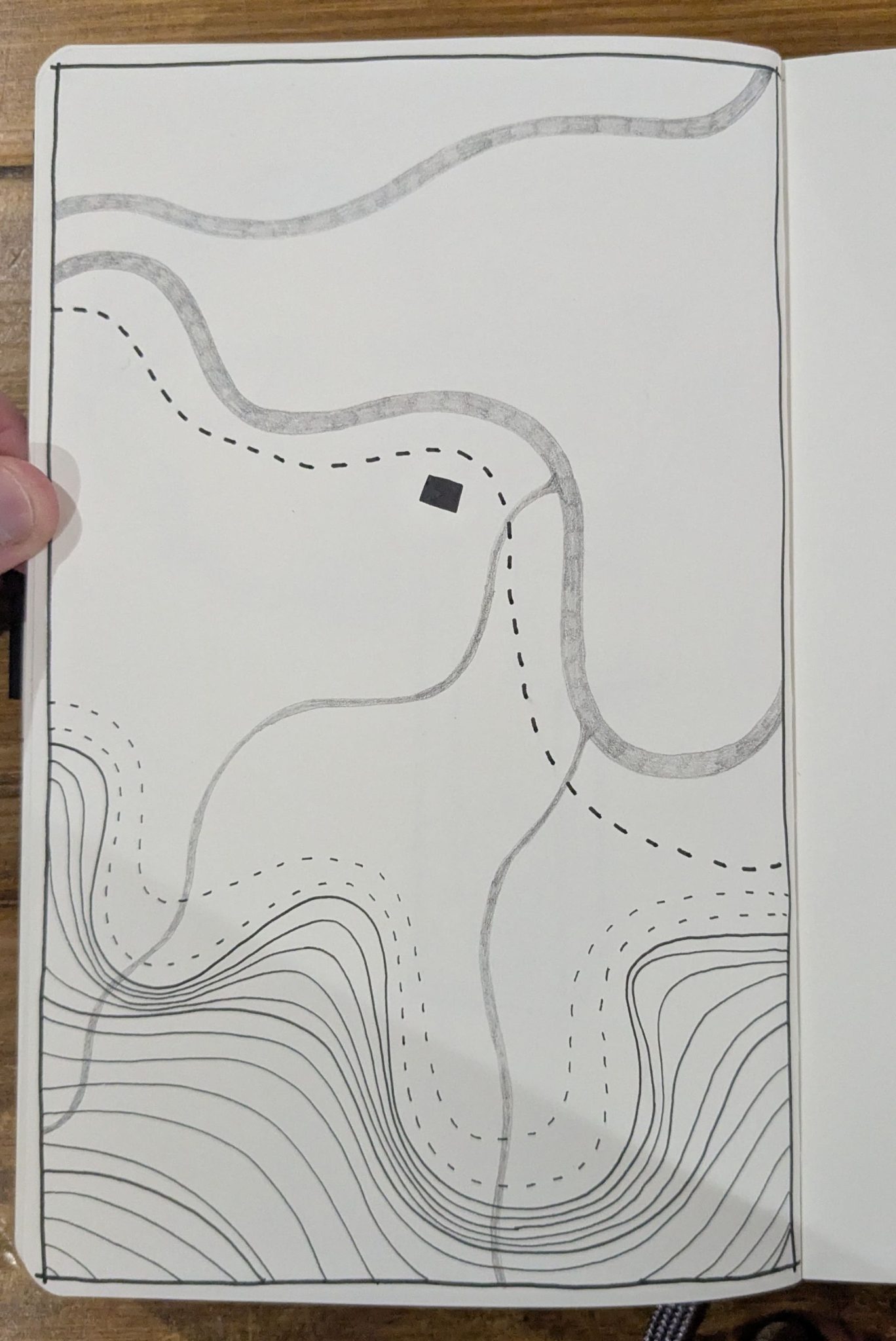 Photograph of a sketchbook page showing an abstract drawing in pen and pencil