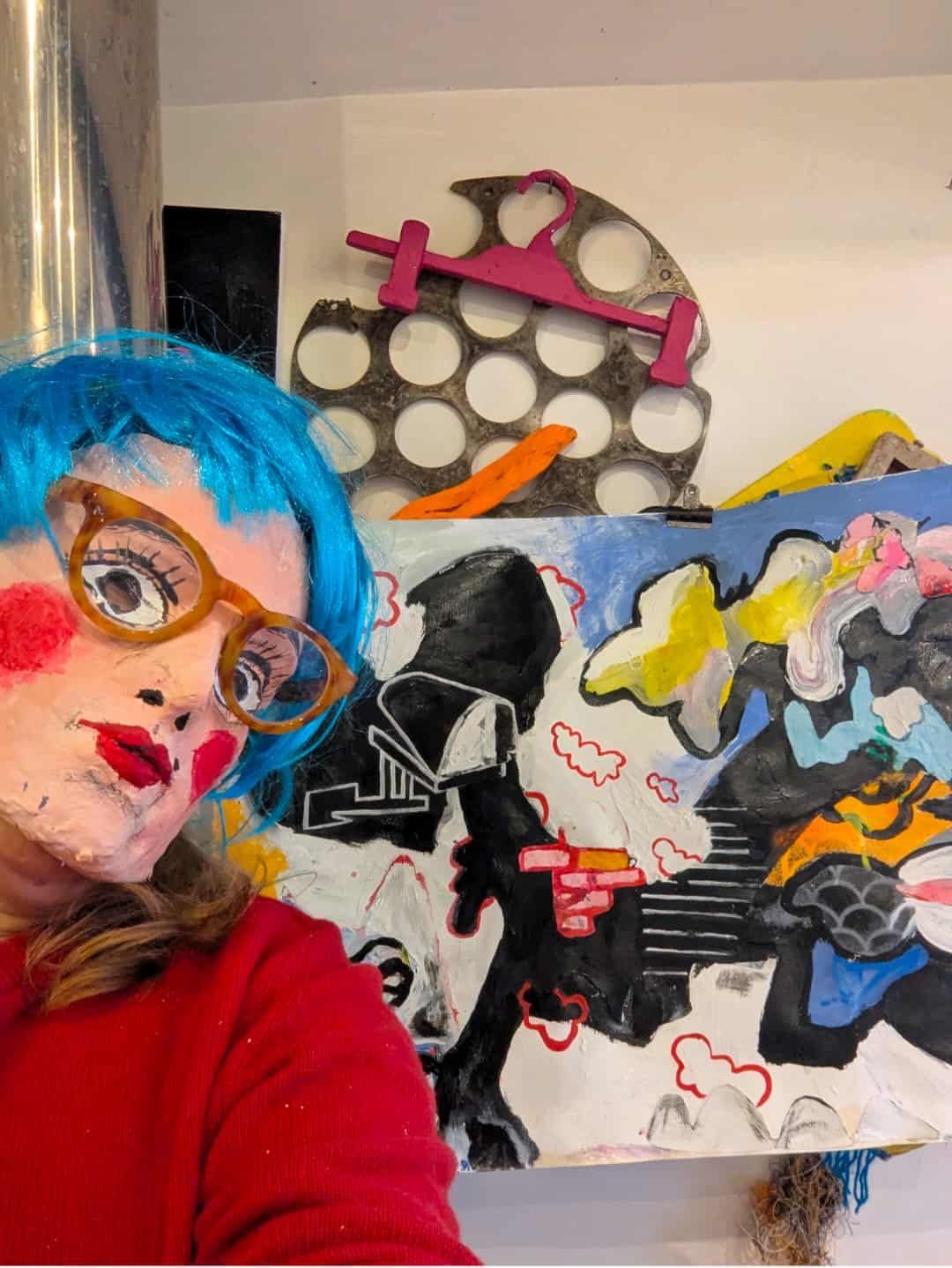 Artist wearing mask, with wall artwork
