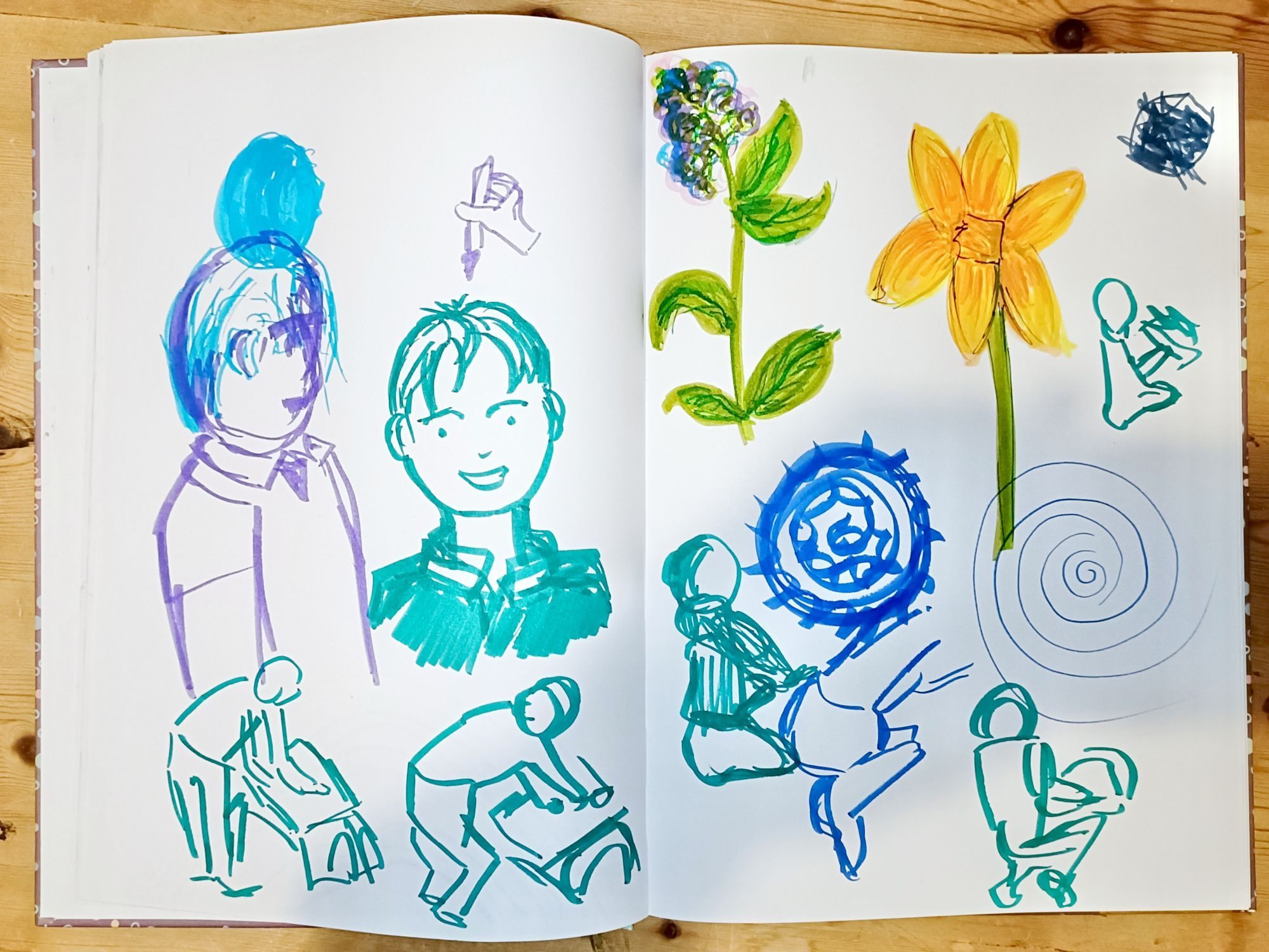 drawings in a sketchbook, including rough outlines of a child drawing and some flowers