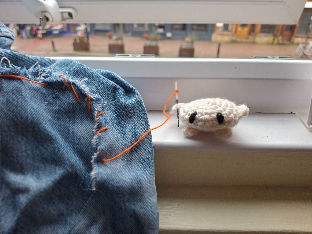 Kirby-like amigurumi stitches up some jeans