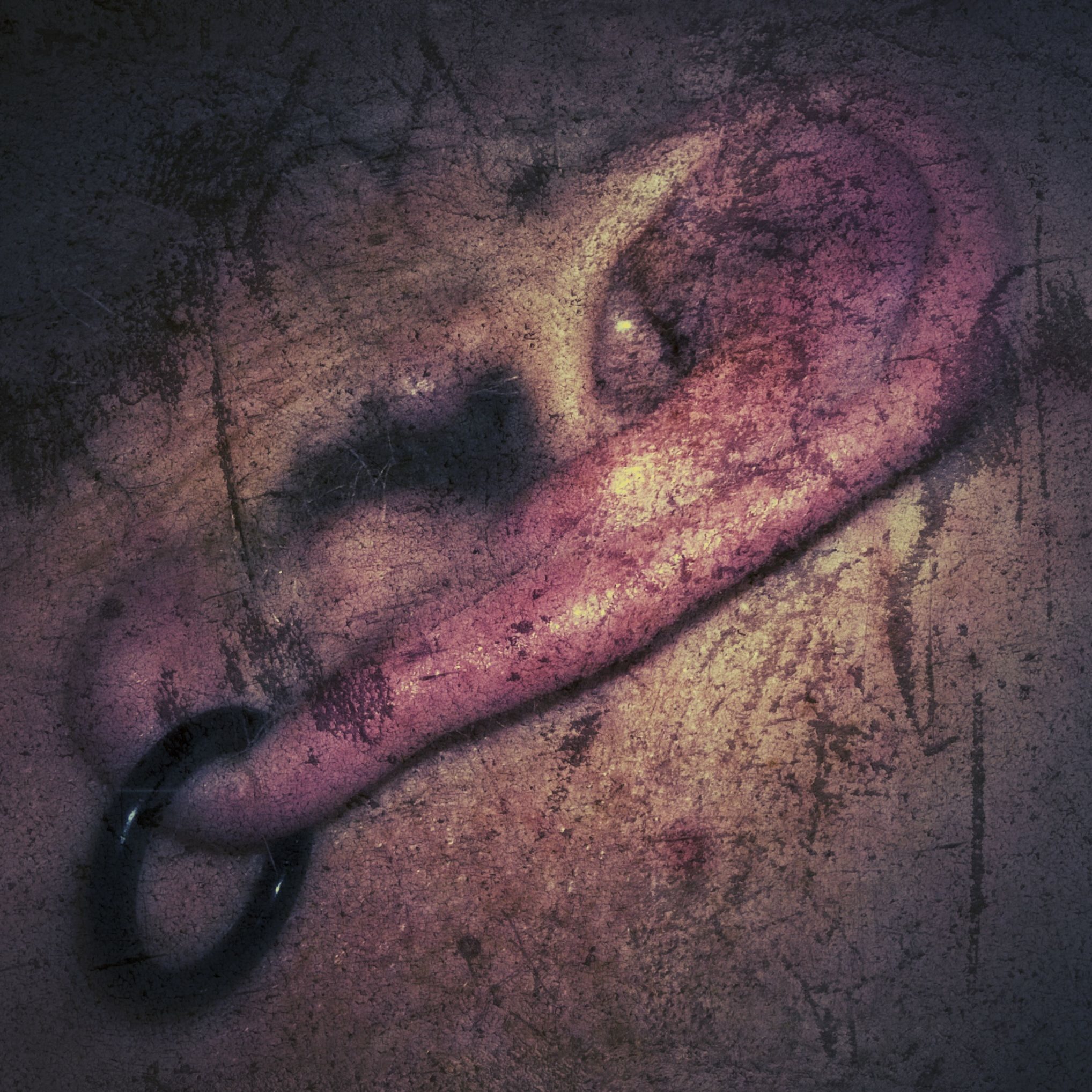 Grungey digital manipulation of photo of close-up of man's ear with black earring