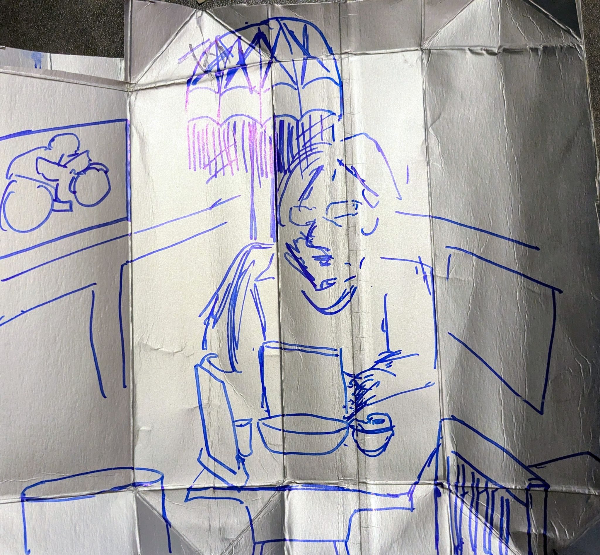 An image of a woman on a laptop in a cafe, on a silver tetrapak