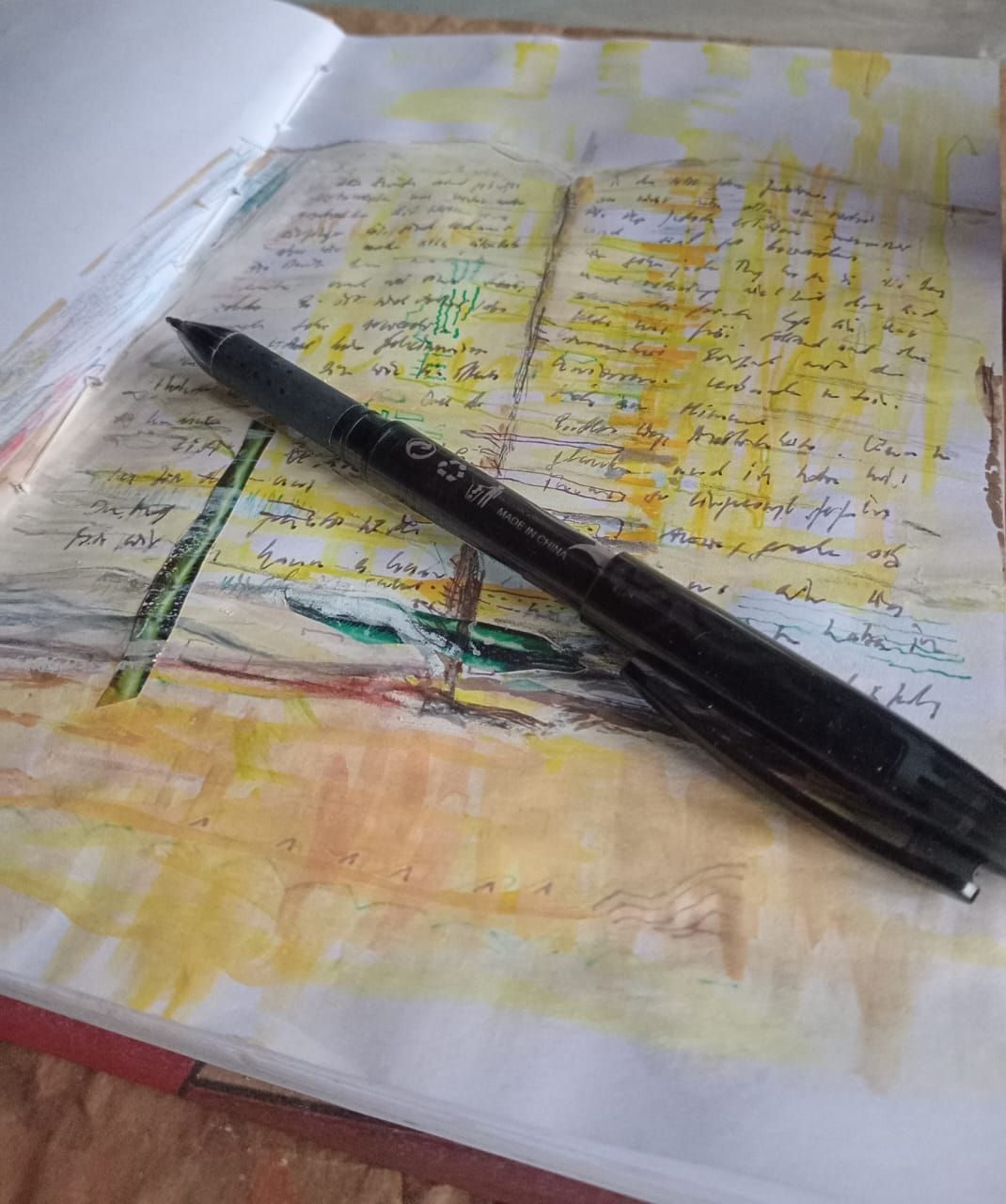 Sketch of an open book with words written down and a pen lying on top of the image