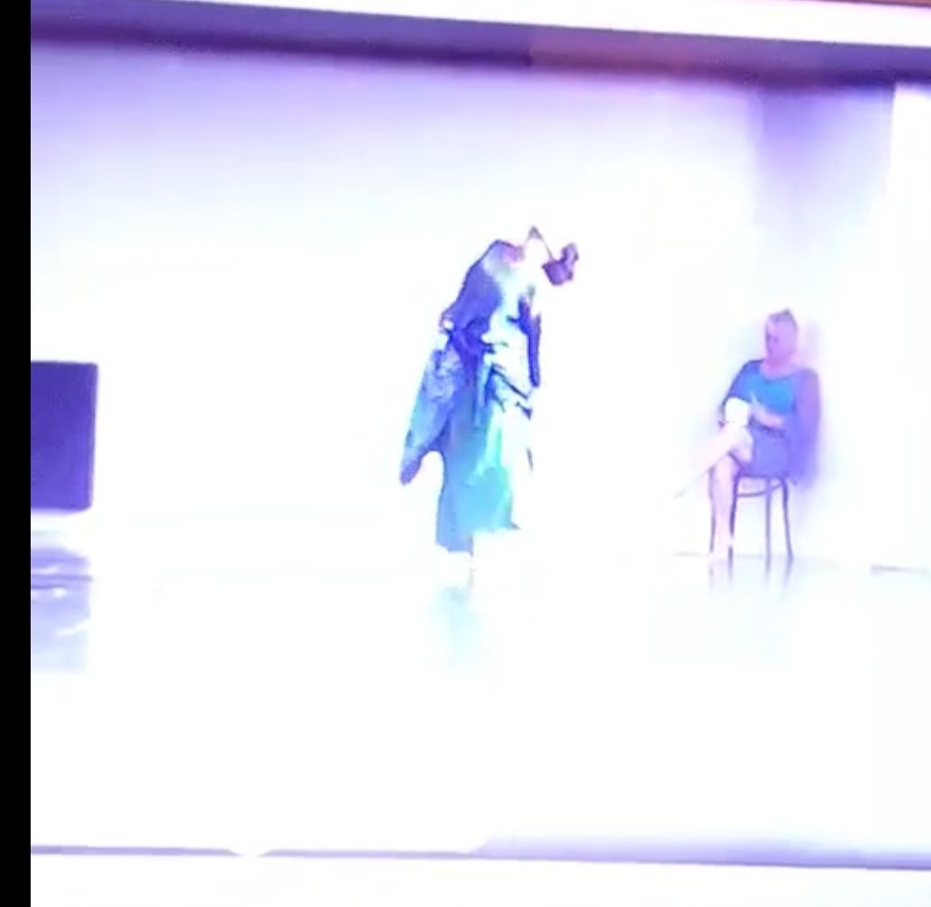 Picture if a yound woman in movement , the face to the sky and a woman artist sat drawing .