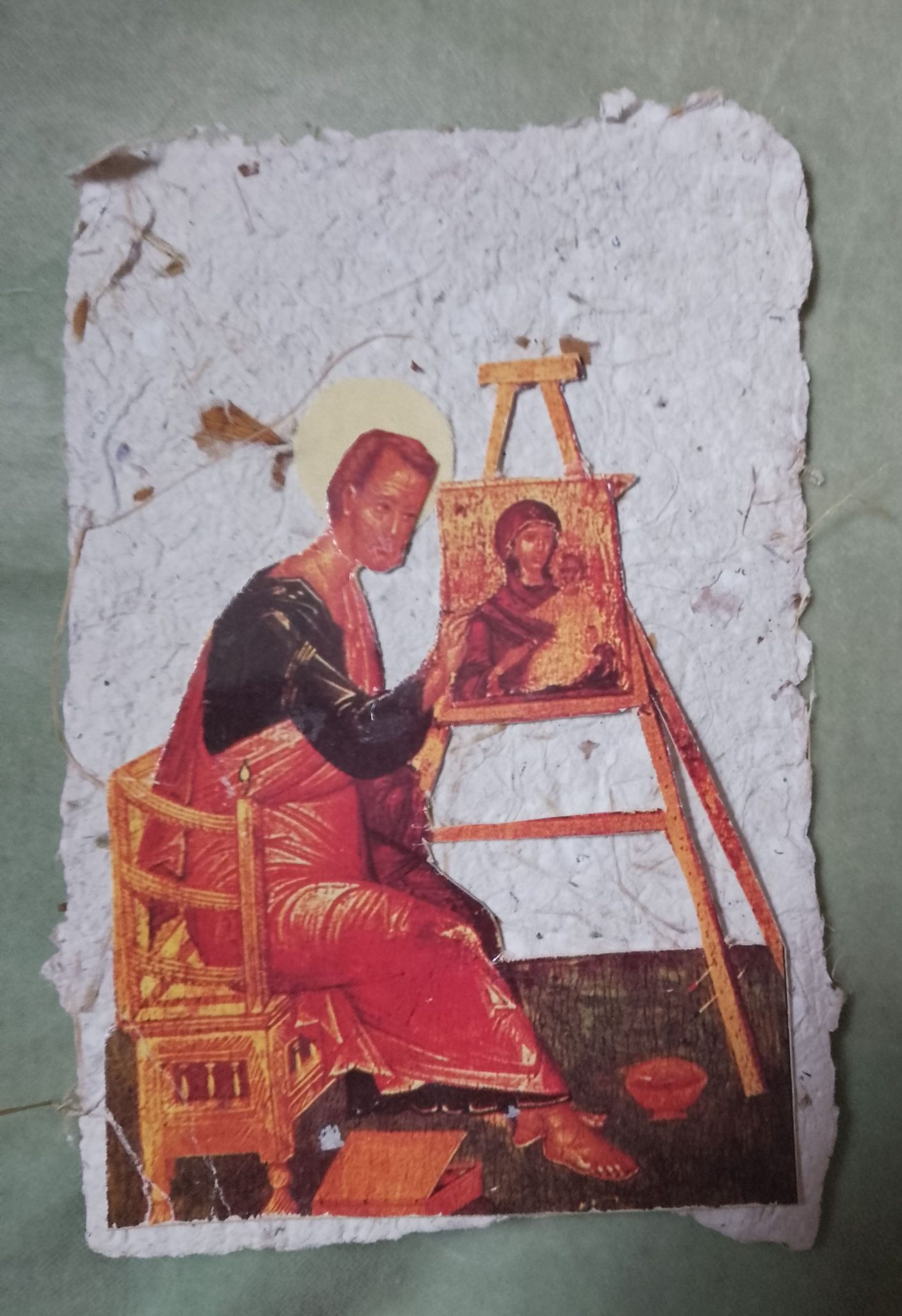 Collage on handmade paper ,image of old Christian icon painter painting an image of virgin mary ,he as a fabric halo