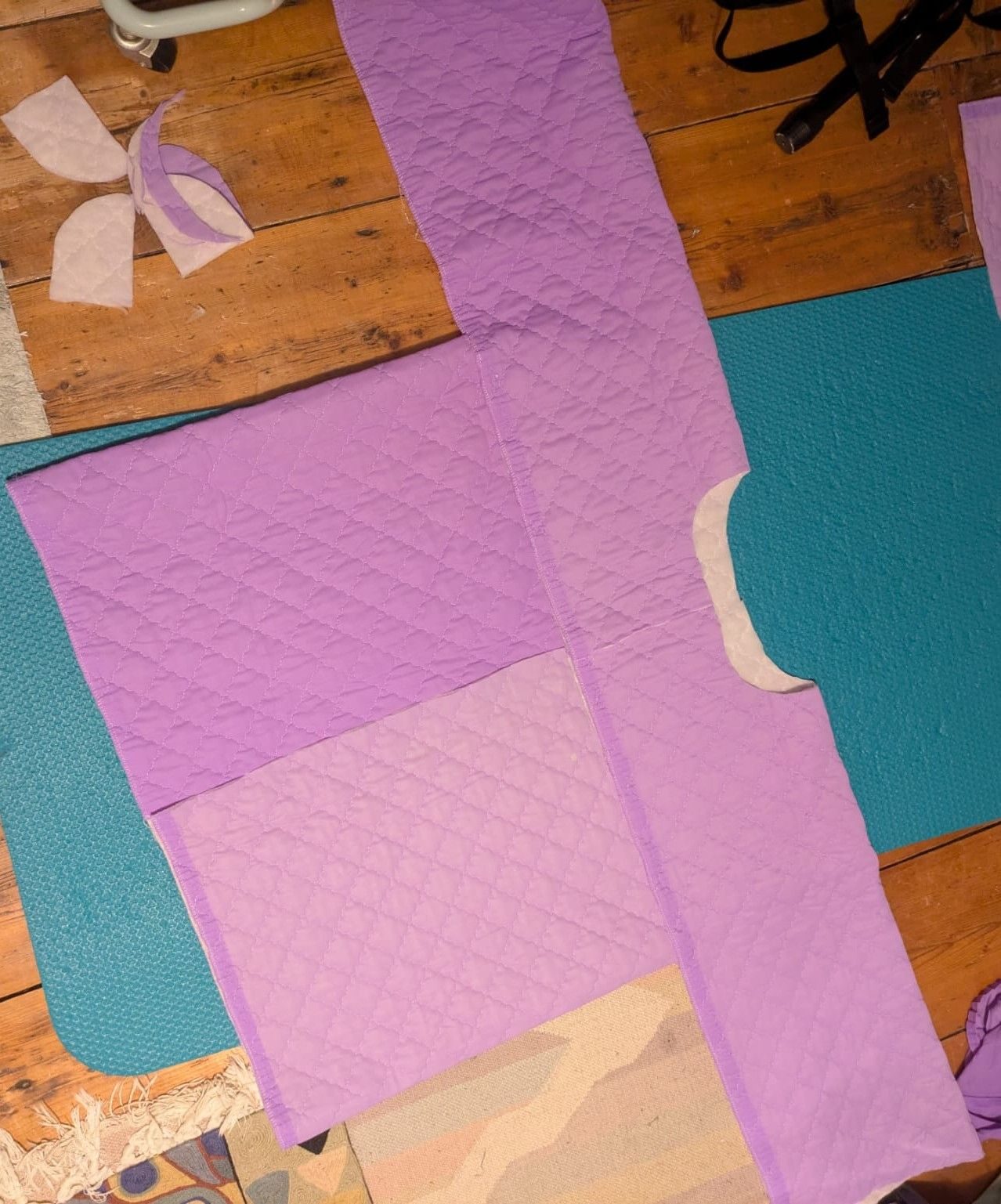 Purple fabric laid on the ground, cut out to a bog coat pattern