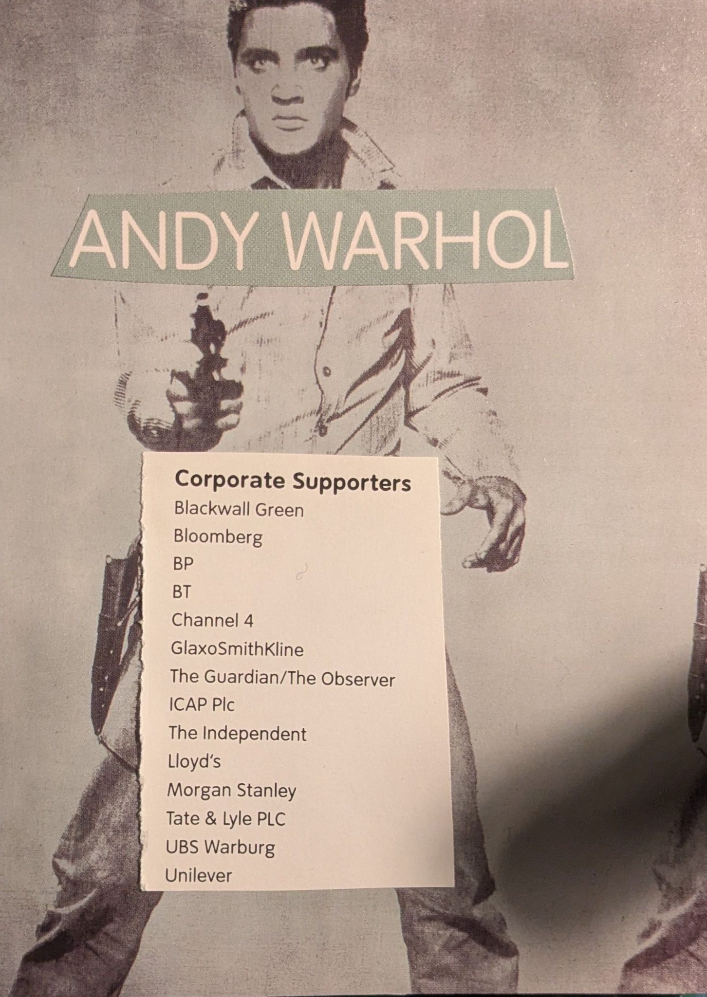 Andy Warhol's portrait of Elvis holding the gun is the background, then there is text which reads 