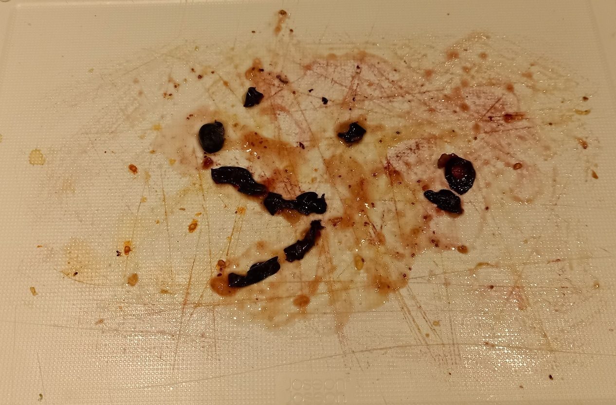 Squashed blueberries on a cutting board, vaguely resembling a bear