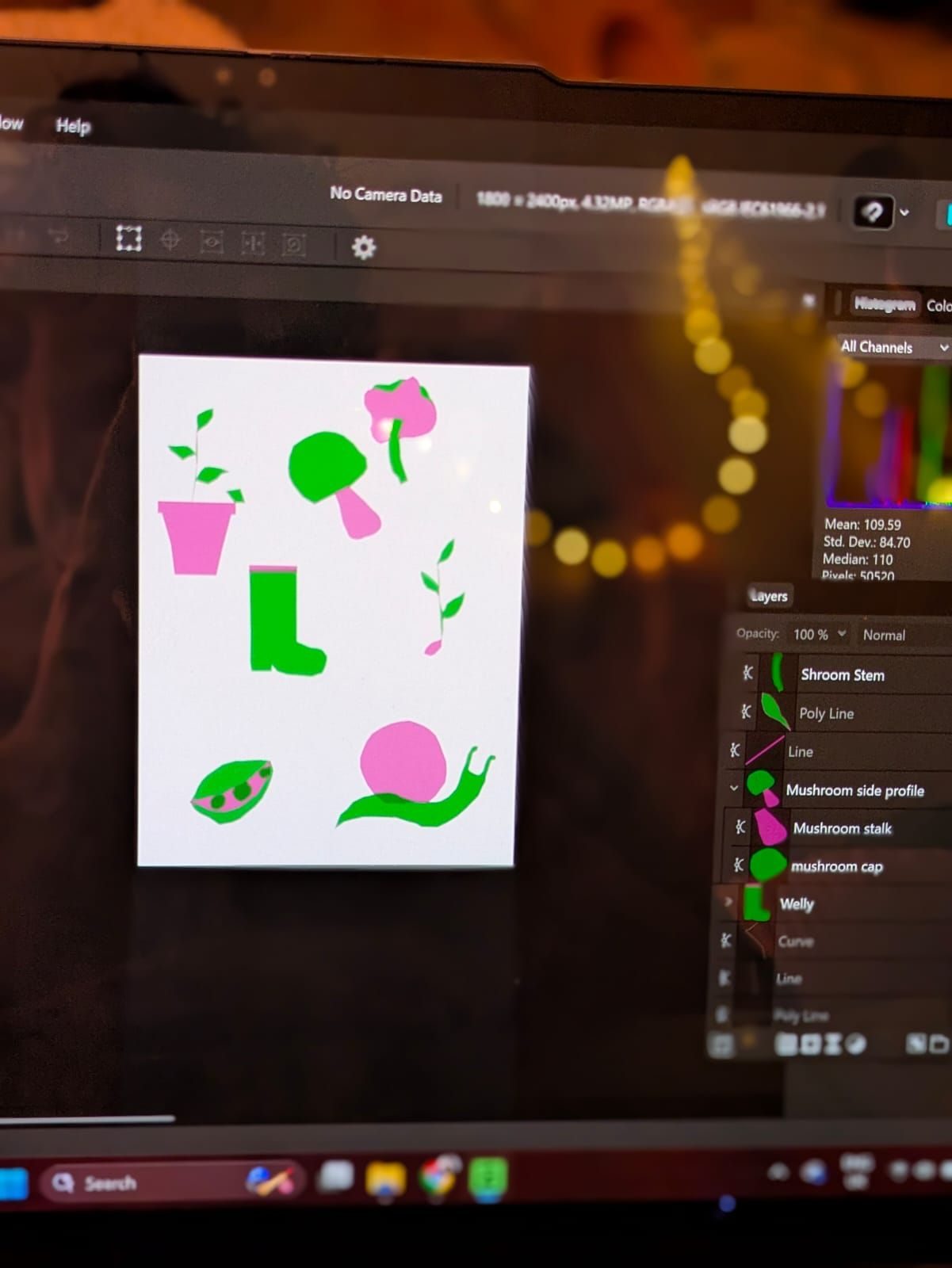 A photo of a laptop desktop with affinity software update and running. On affinity the artist has drawn basic shapes of 2 mushrooms a snail, a seedling a pot plant, Welly and pea pod