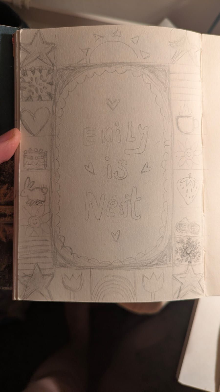 A drawing of a grid in the middle it says Emily is near around it is sketched things Emily likes like bunnies a rainbow wool granny squares a trans flag and more