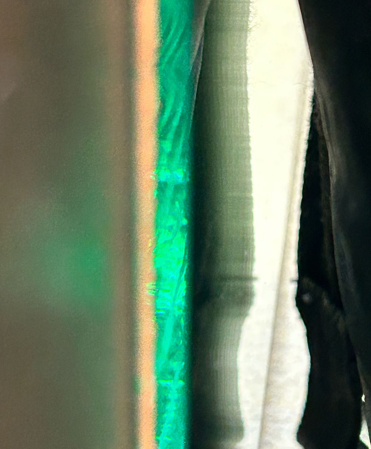 close up photo of a green reflection from a mirror bevel.