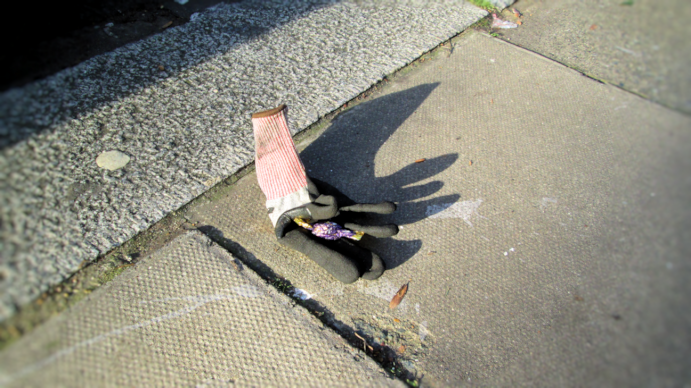 in the bright sun the shiny wrapped sweet, a chocolate eclair, toffee with runny chocolate int eh middle, glints int eh cupped hand of the discarded glove, inviting the lucky finder to stoop and see if the pavement prize is really what it appears to be or a message left by one of the local homeless street people who stash their drugs in plain sight for their 'customers' to collect at leisure
