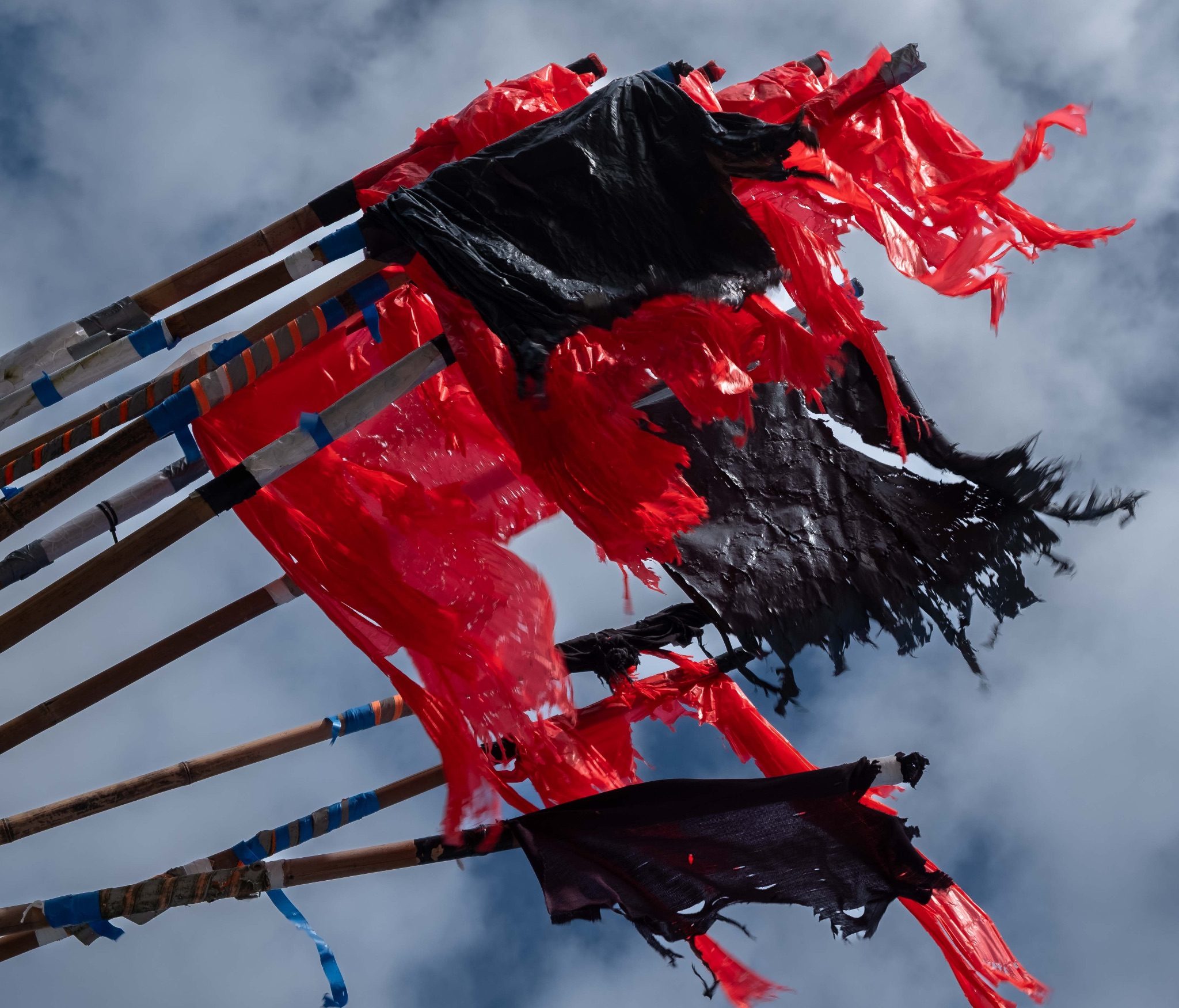 Tattered plastic flags in red and black fluttering in the breeze