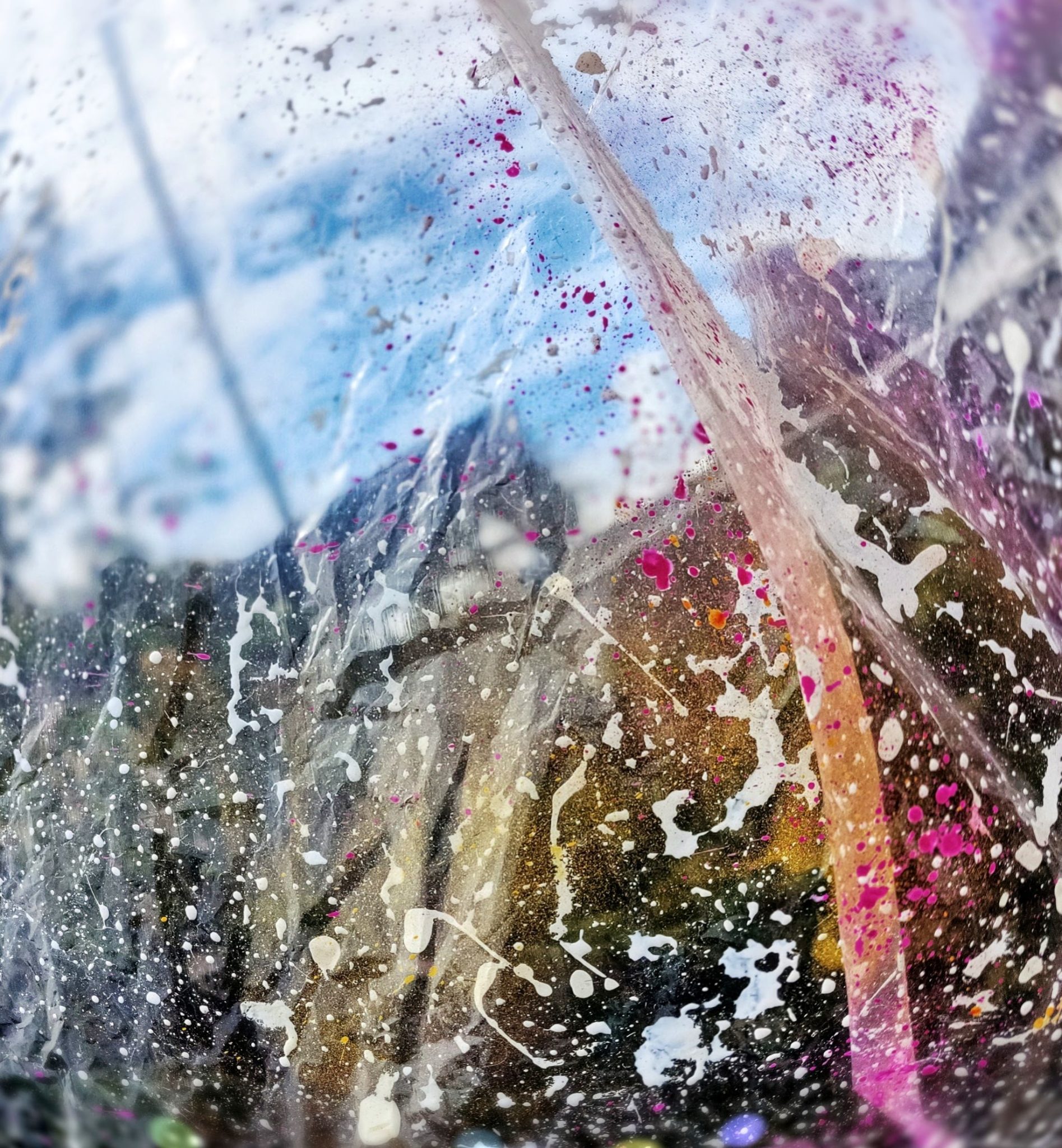 colourful transparent splatter sheet hung on line to dry during periodic downpours
