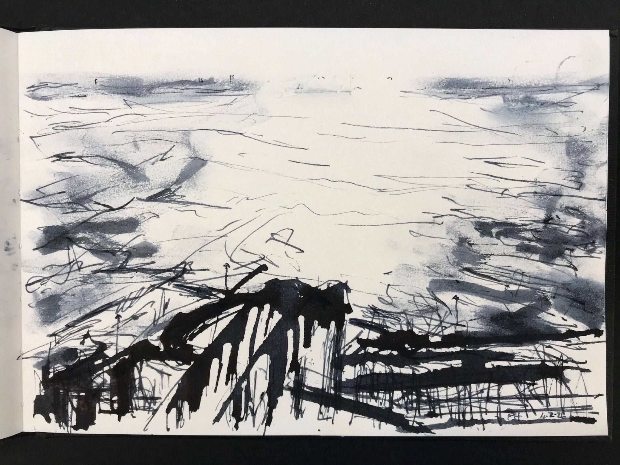 Black pen and ink drawing on white paper. There is a black bridge like shape in the centre of the bottom of the drawing, positioned on a diagonal rising from left to right. the inking of the bridge is bold and dark black with vertical streaks which might be railings. Around and under the bridge are other dark marks, lines that could be walls. The top two thirds of the paper is mainly covered in a series of light abstract marks and smudges with a large circular area in the middle left mainly white paper as if the sun is reflected on the water. There is a vague horizon near the top of the drawing wth a few marks that might be buildings.