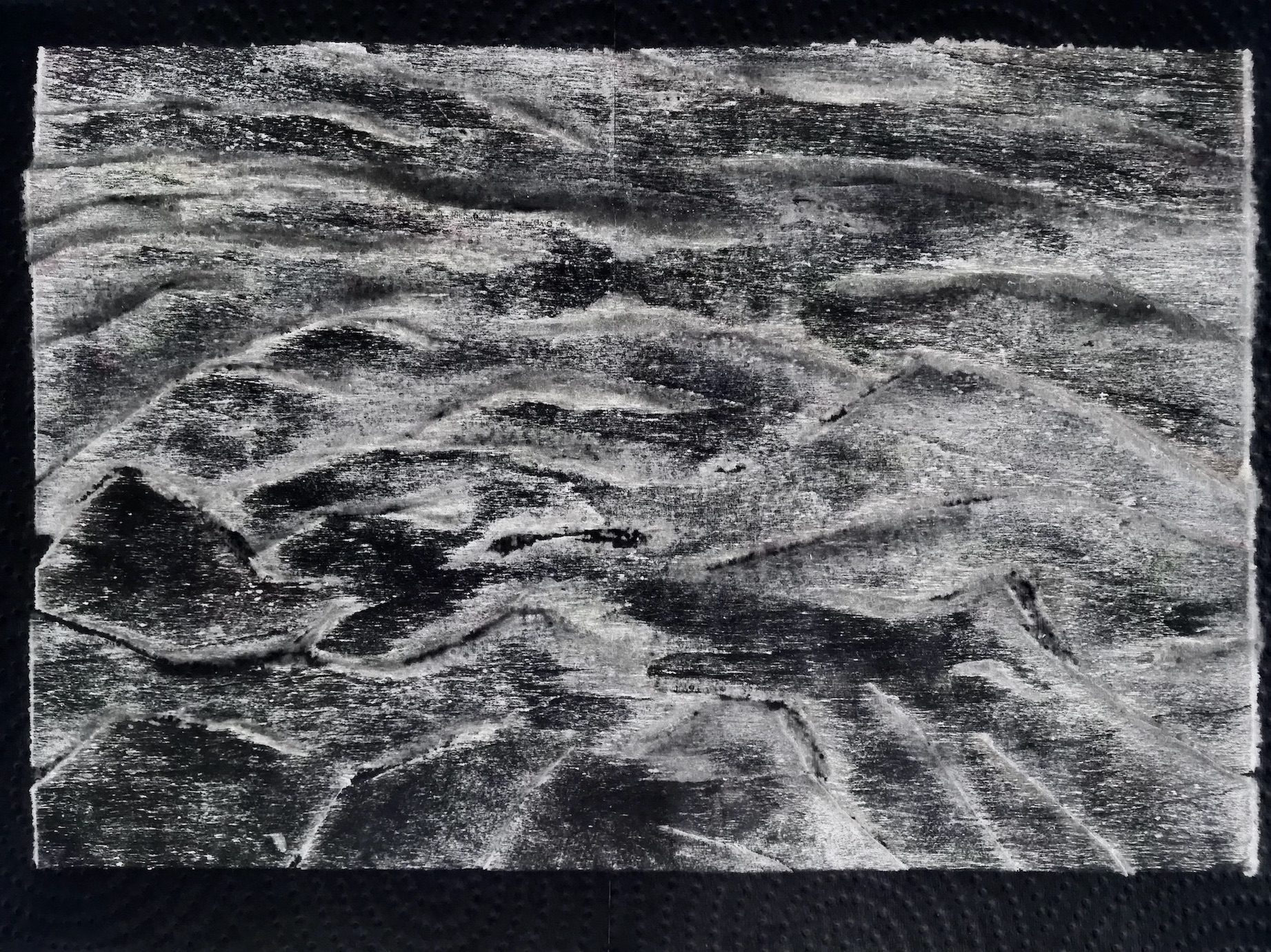 Black and white landscape print of a woodcut. Appears to be like roiling sea, turbulent water . The edges of the cut wood are softened as this image is after spraying the wood with water and printing on kitchen paper and the positive made negative in editing software.