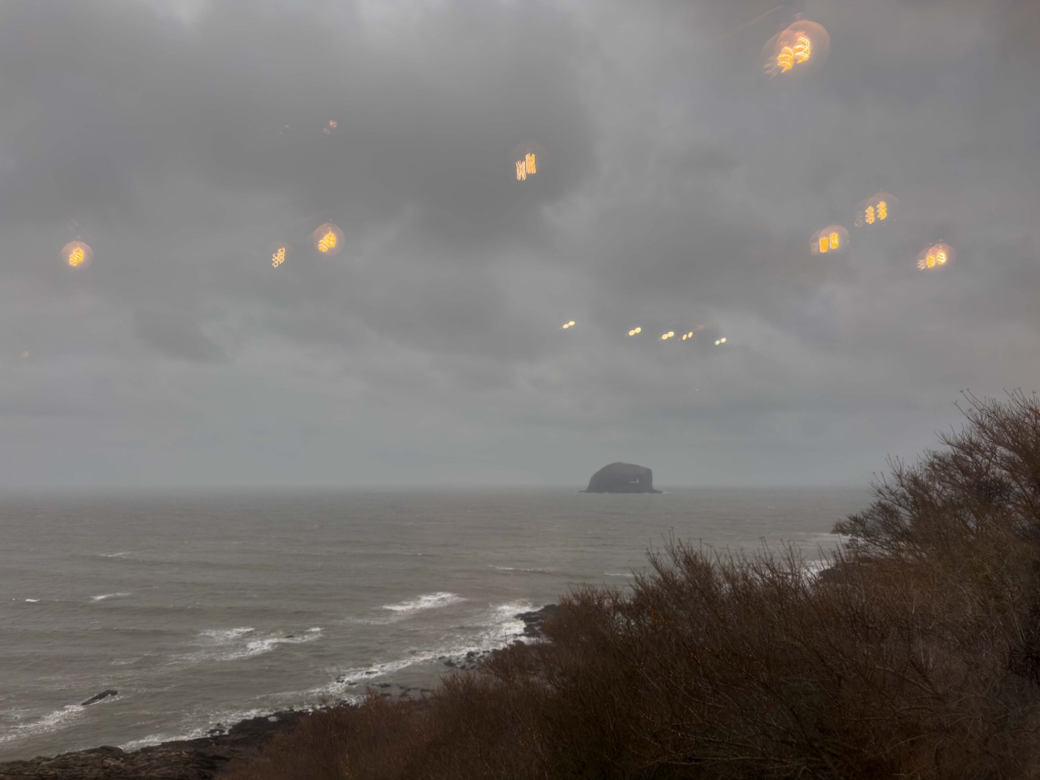 Reflections of light bulbs appearing in the sky around Bass Rock, Scotland