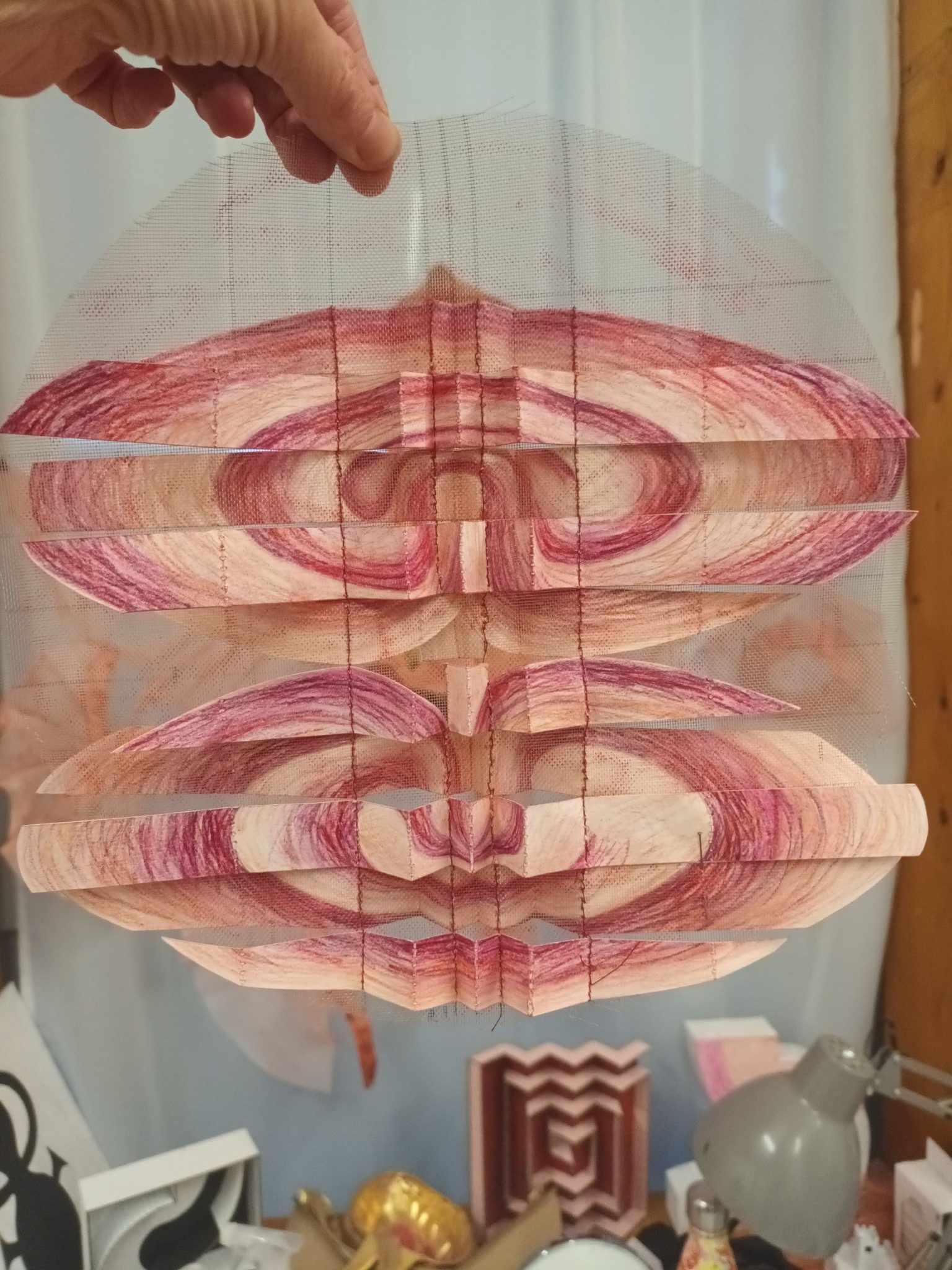 Paper spiral zig zag, mirrored horizontally, red and orange colour, stitched onto gauze.