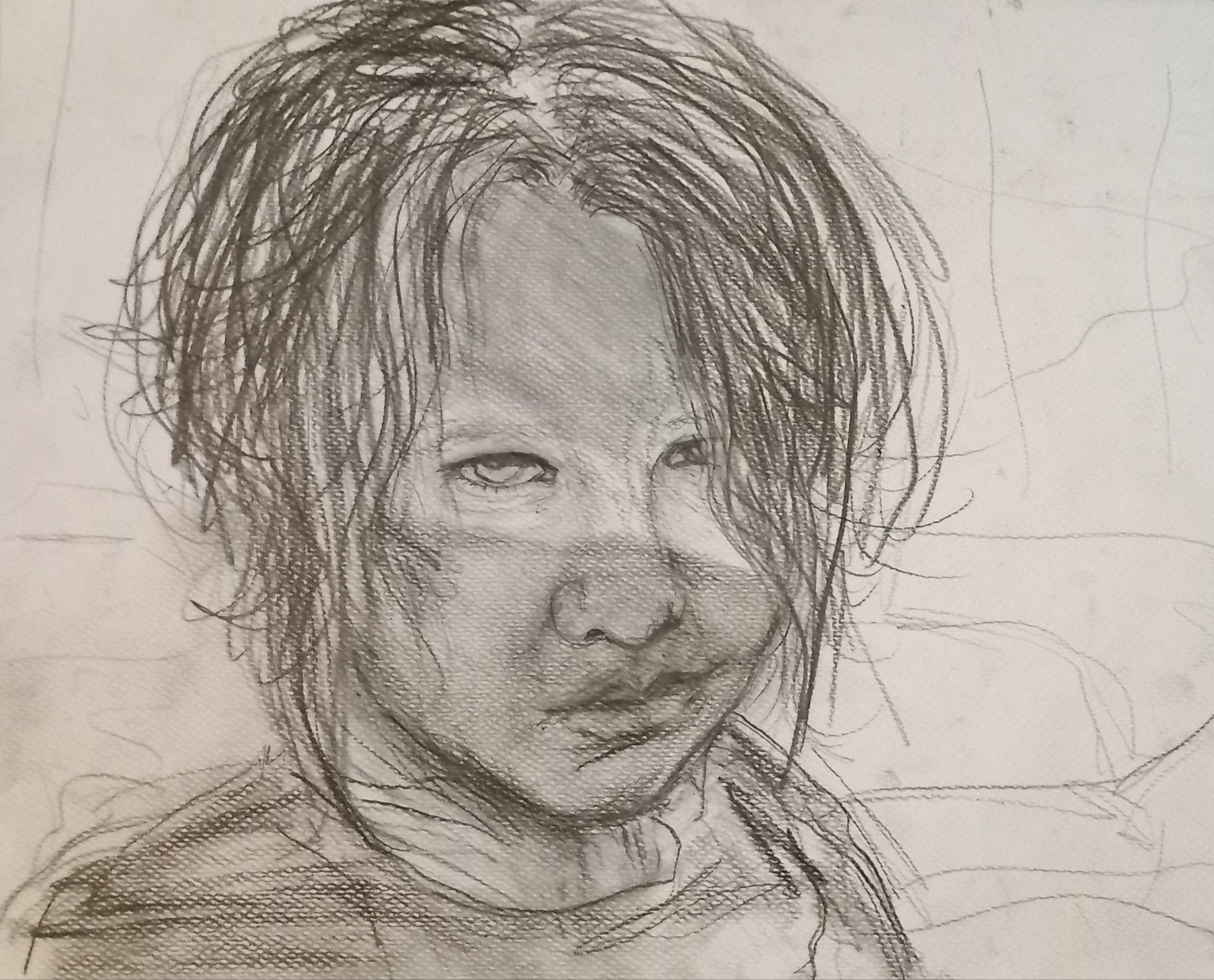 a charcoal and pencil of my son Finn, his eyes are lit by the sun and rest of face in shadow