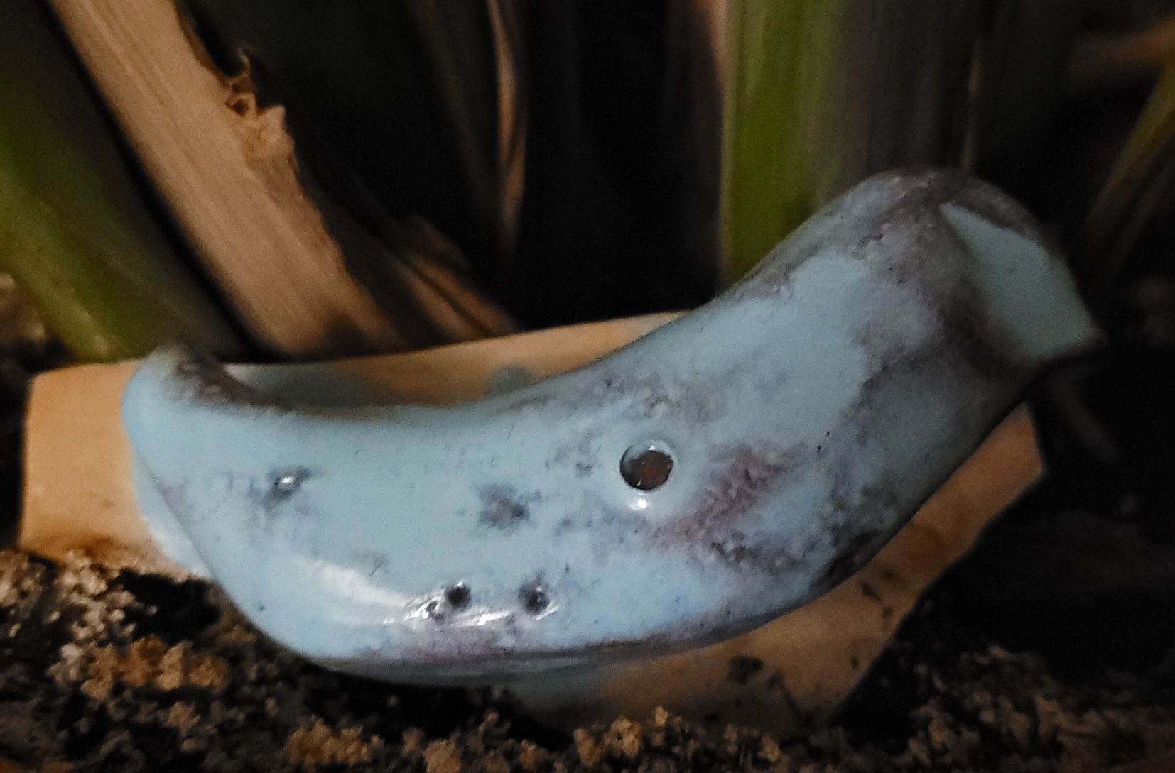 Clay bird in.plant pot