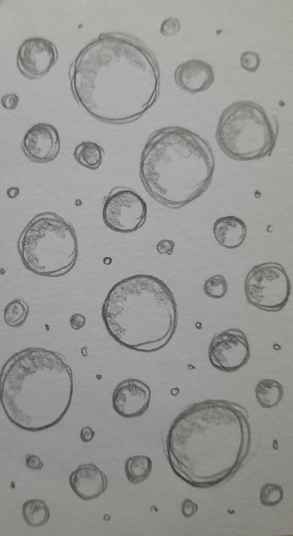 Pencil drawing of a bunch of randomly sized circles. From larger circles down to just dots.