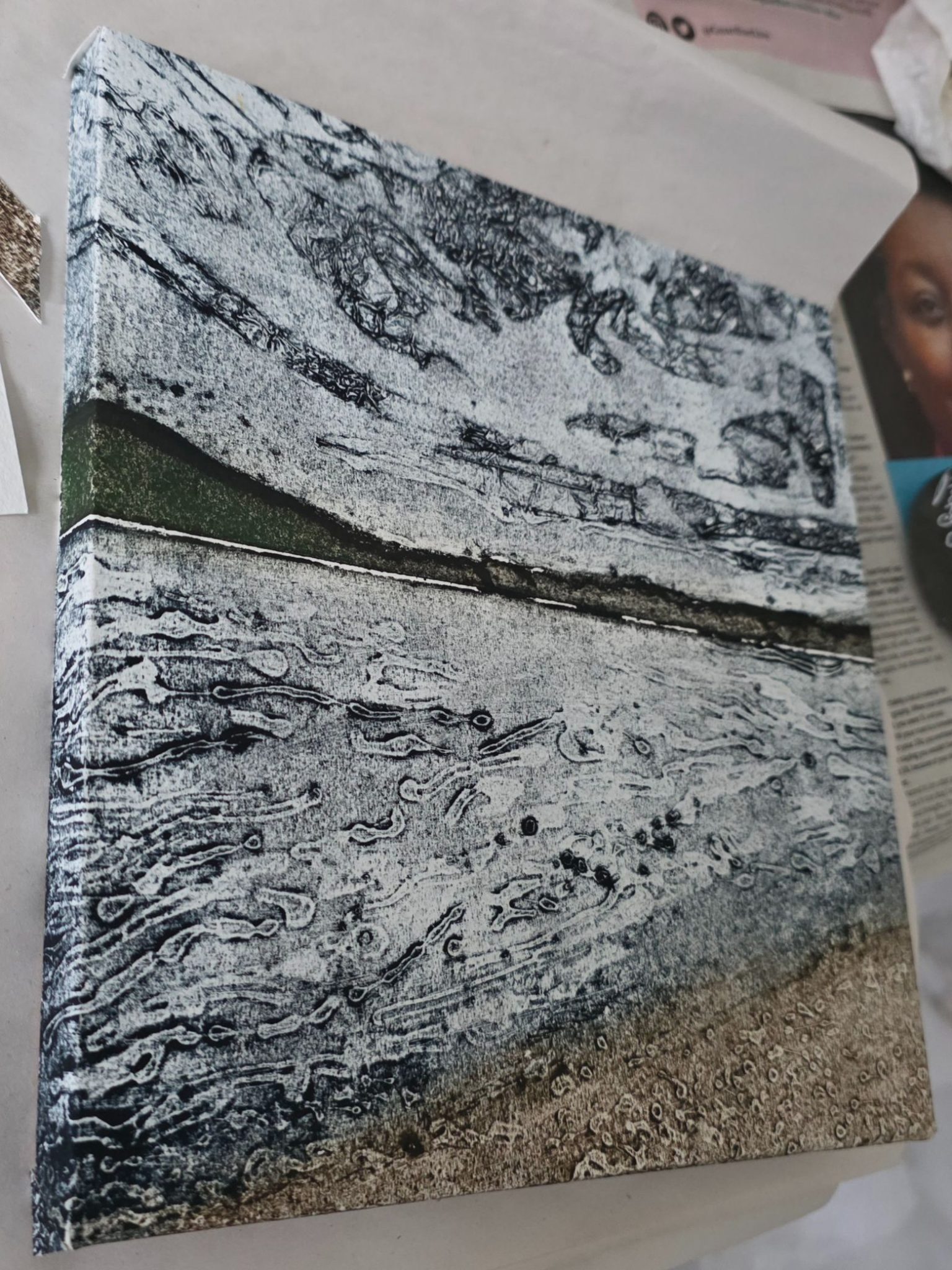 Picture on a block showing mountains, sea and stony beach