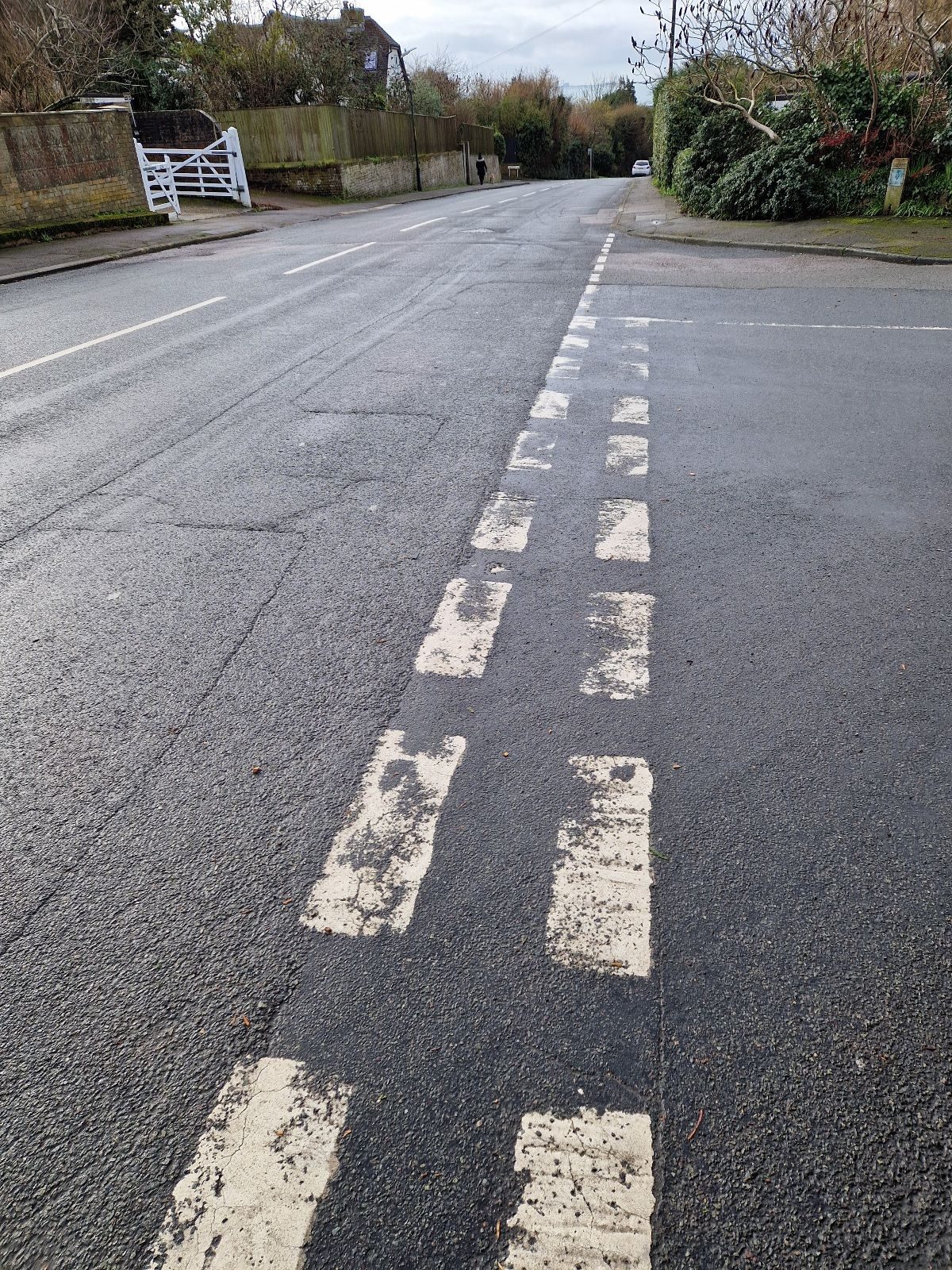 photo of a road junction with double white dash lines and Dungerbess power station in the far distance taken while out walking,