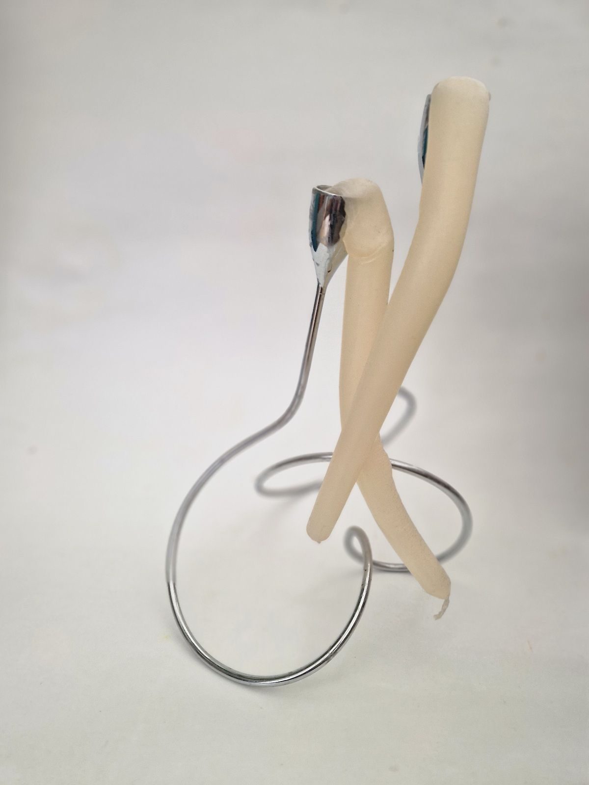 Candel holder with two candels that have slumped over like legs