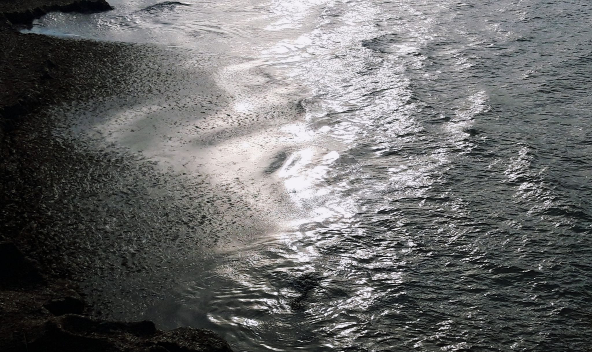 Light reflected on the surface of the deepas the waves build a seagrass forms that will wash away in tomorrows tempest