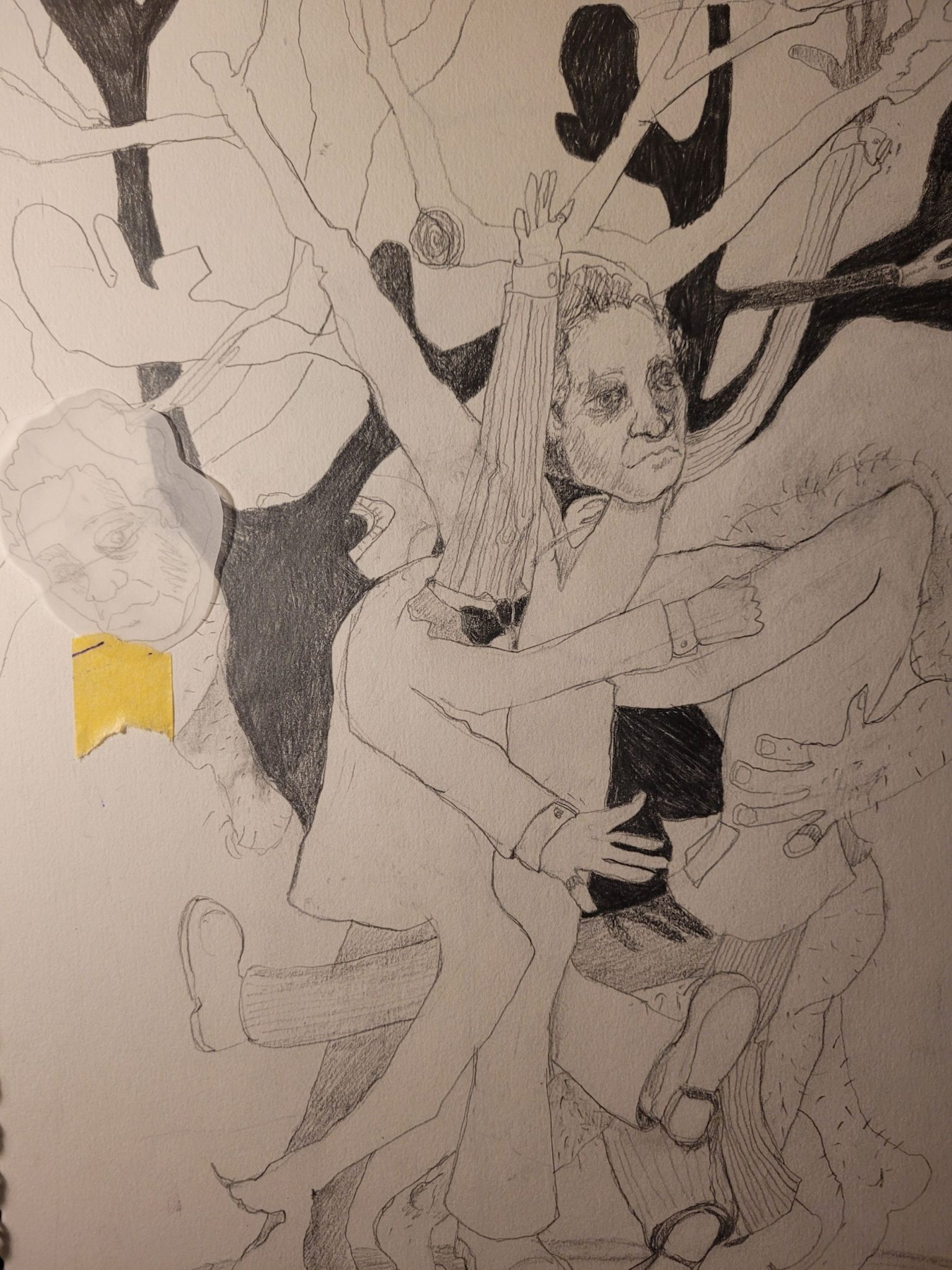 A drawing of figures, branches and horns with an additional head taped in with yellow tape