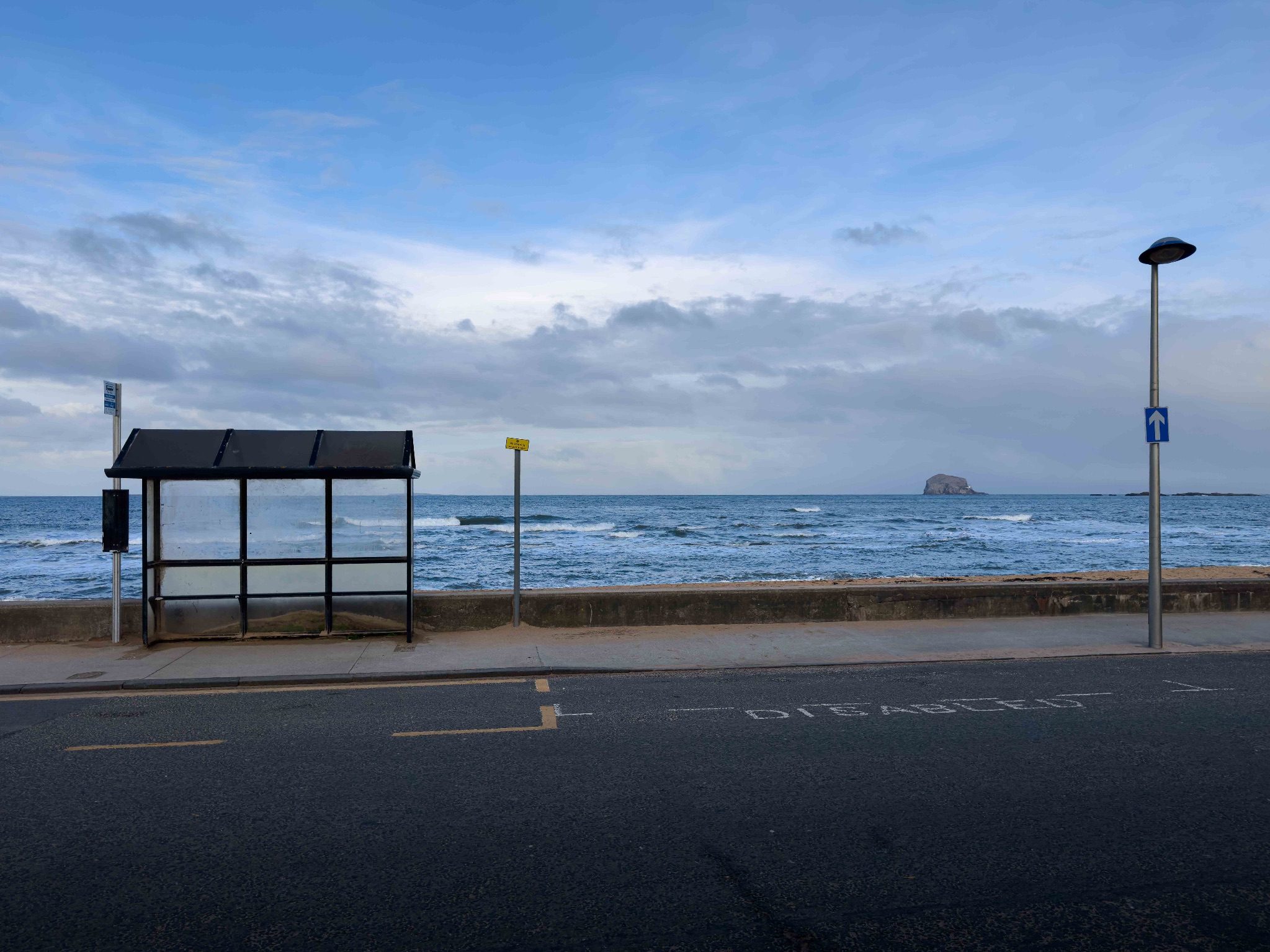 Picture of a seafront bus stop with Bass Rock on the horizon