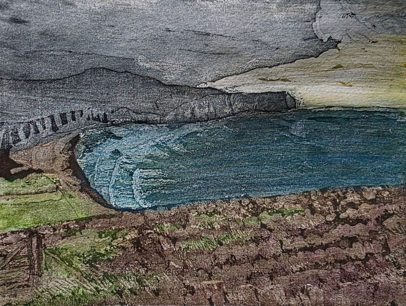 A misty headland with a bluey/green sea below - lots of waves. A grassy/heatherly foreground