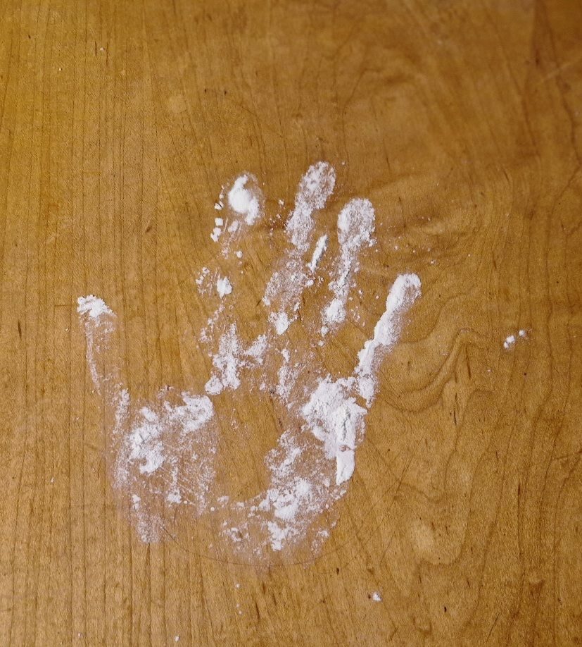 hand print from flour on a wooden surface