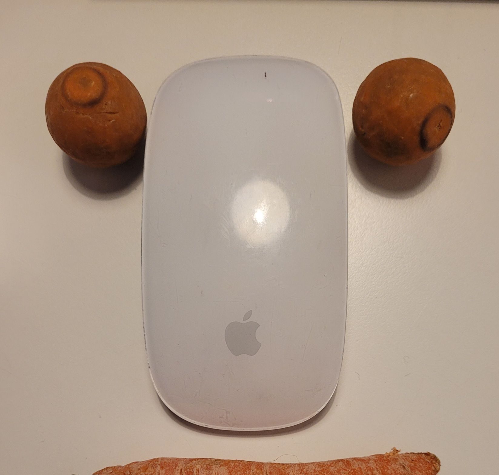 A photo of an apple mouse, as a nose and two chocolate bon bons as eyes.