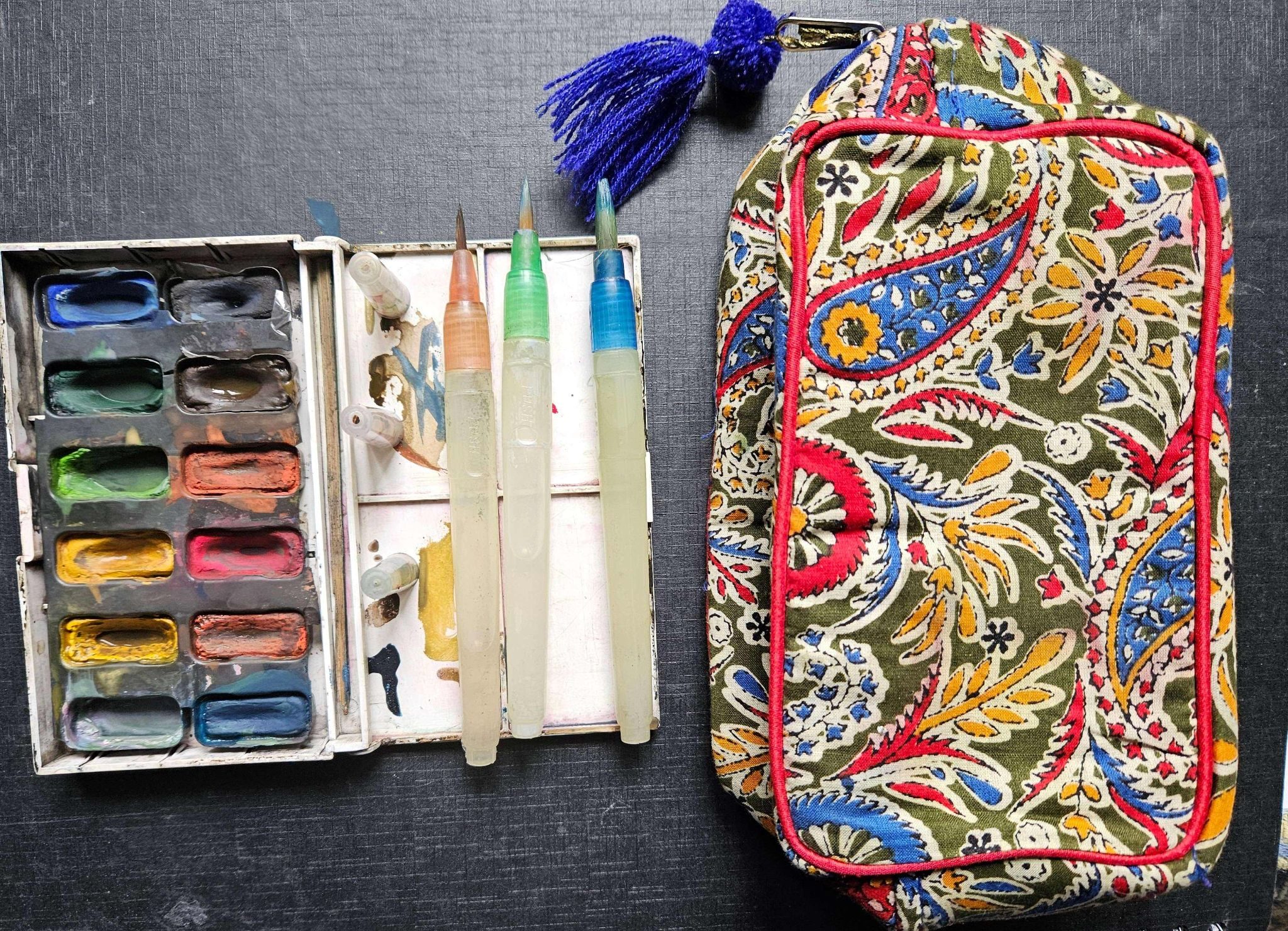 Photo of small water colour paint set with three brush pens and a small zipped  multicoloured pencil case to put everything in